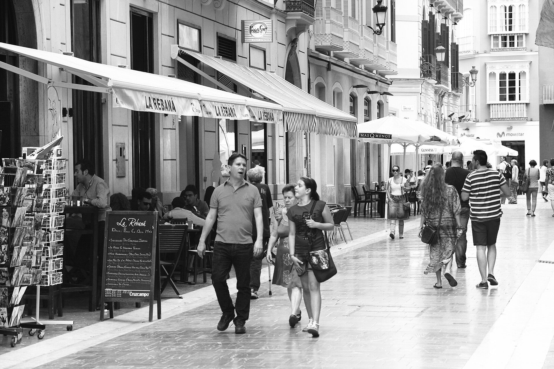 A spacious room with a balcony, offering a city view, featuring modern decor and large windows.