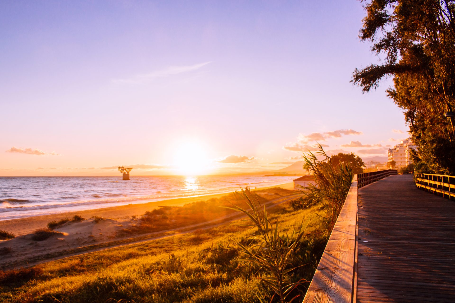 Cozy beachfront room with ocean view, wooden deck, and sunset.