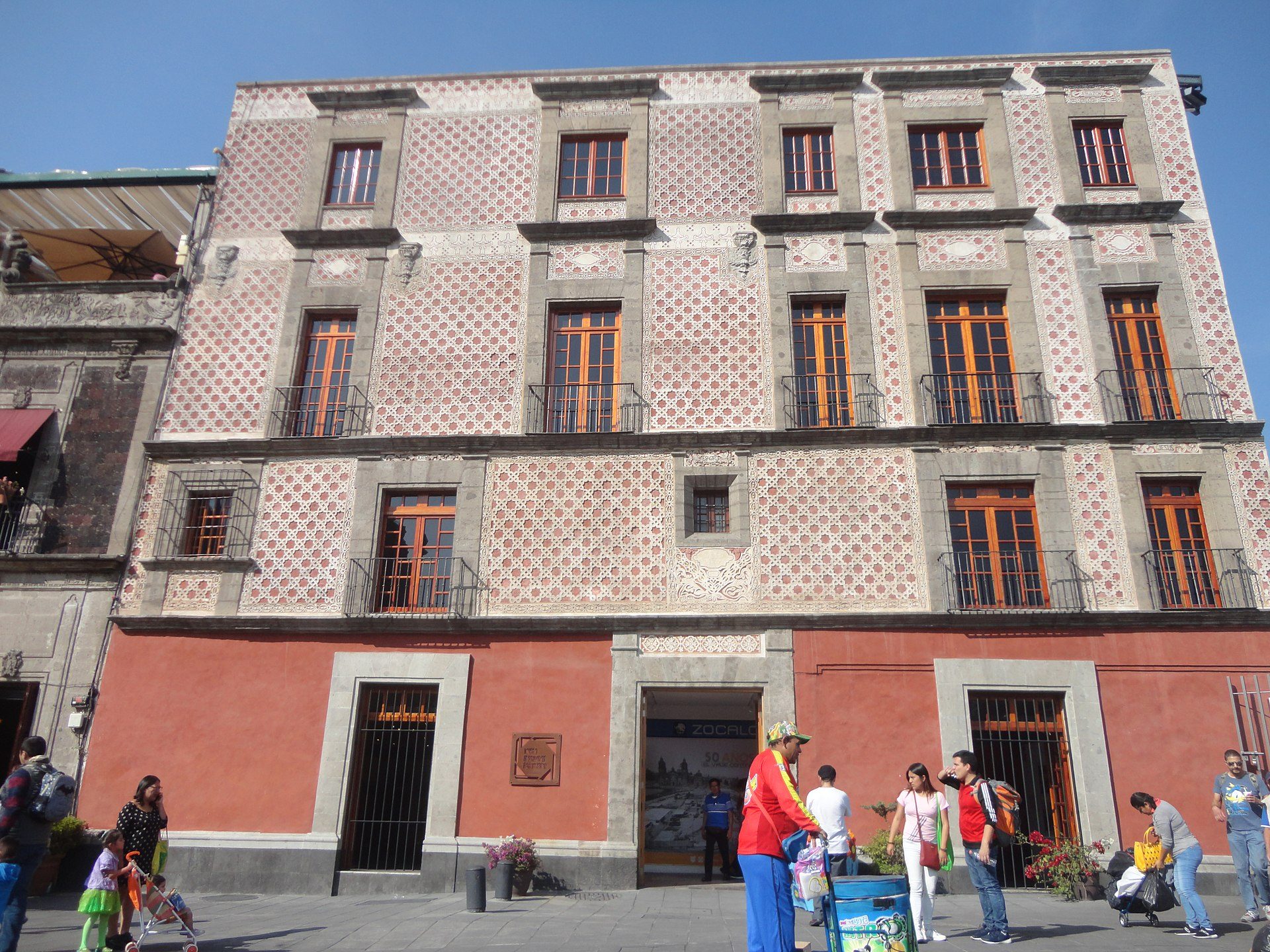 A historic building with a courtyard, featuring ornate tile work and large windows.