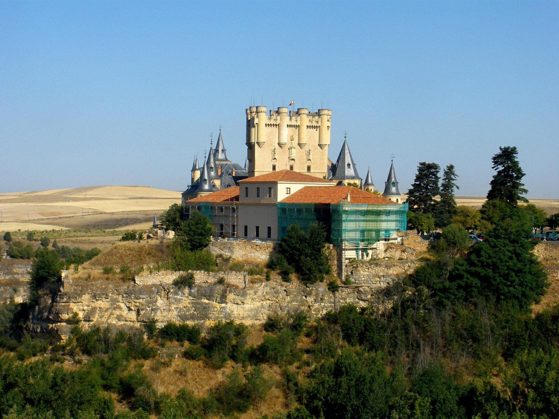 A medieval castle with multiple towers and a panoramic view of the surrounding landscape.
