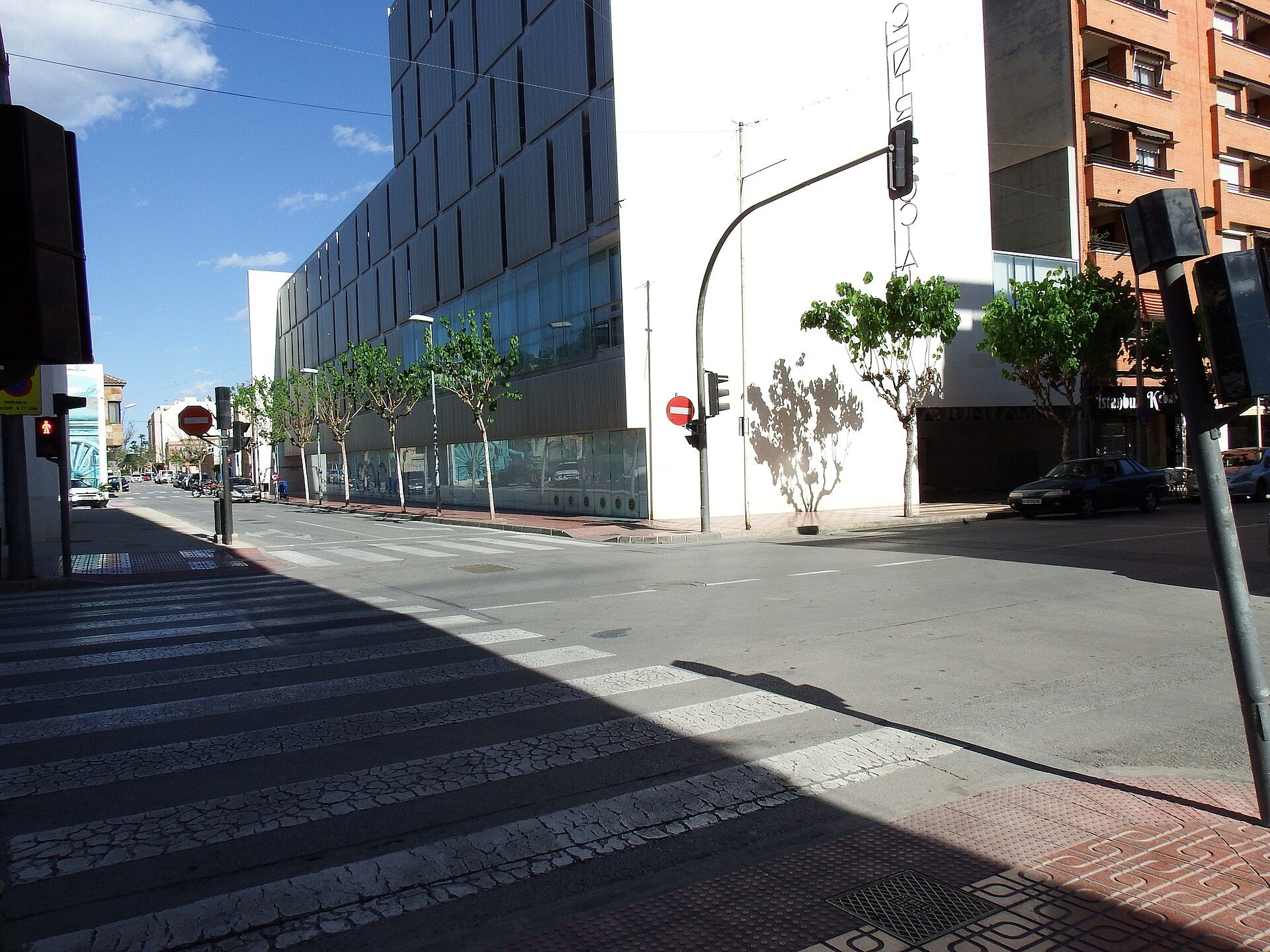 Modern apartment with city street view, large windows, and balcony.