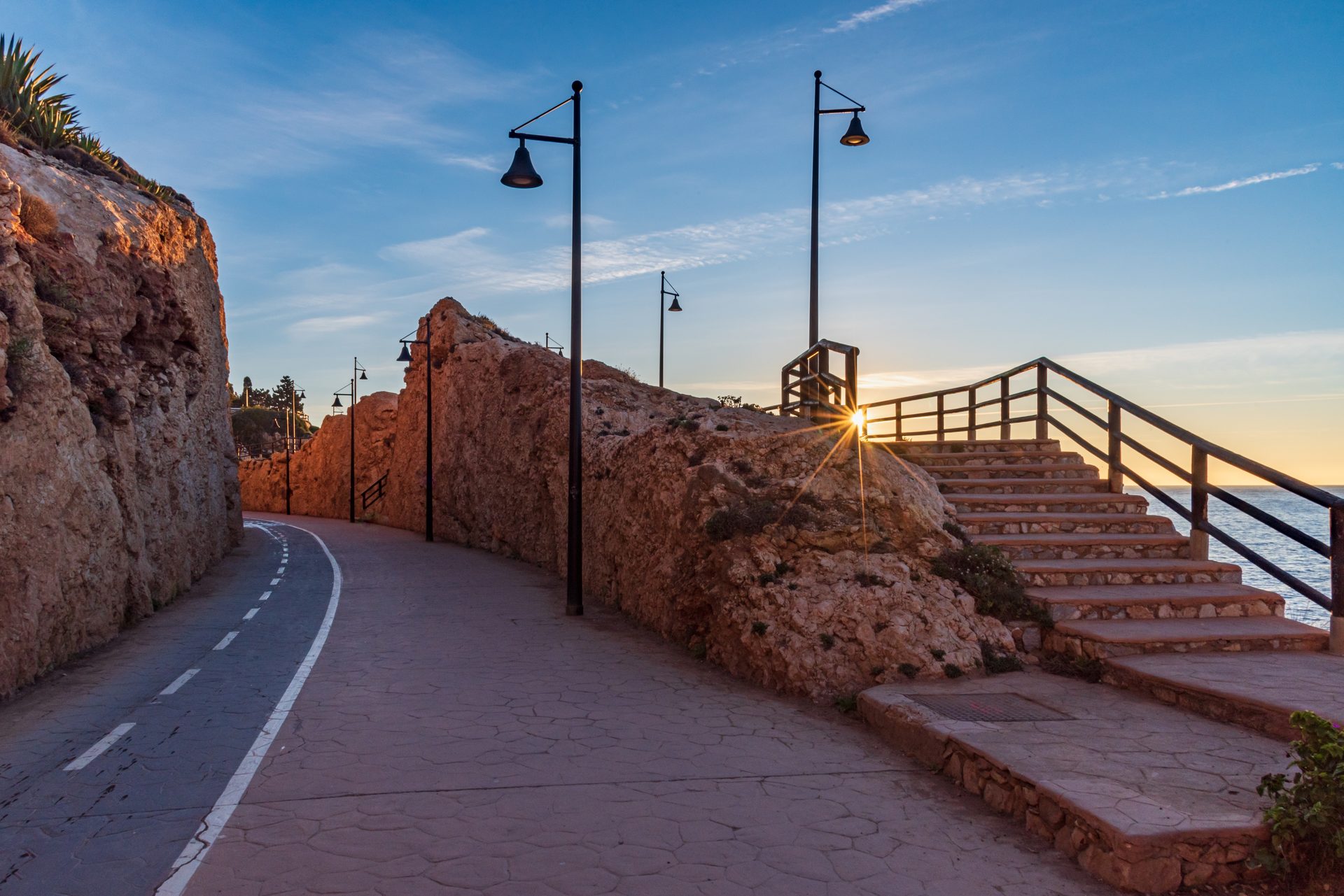 Cozy coastal room with ocean view, stone walls, and sunset stairs.