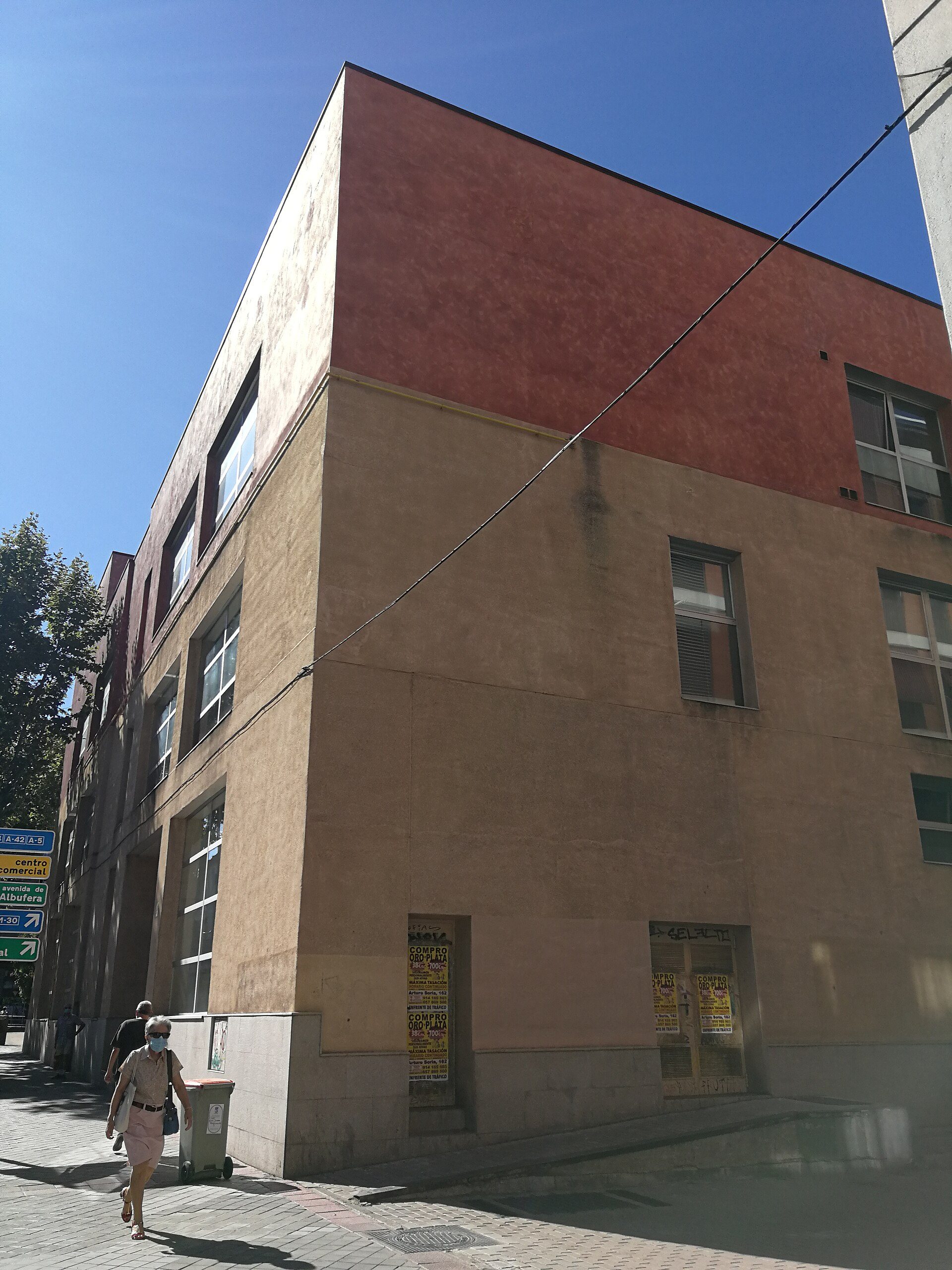 A modern apartment with a city view, featuring large windows and a balcony.