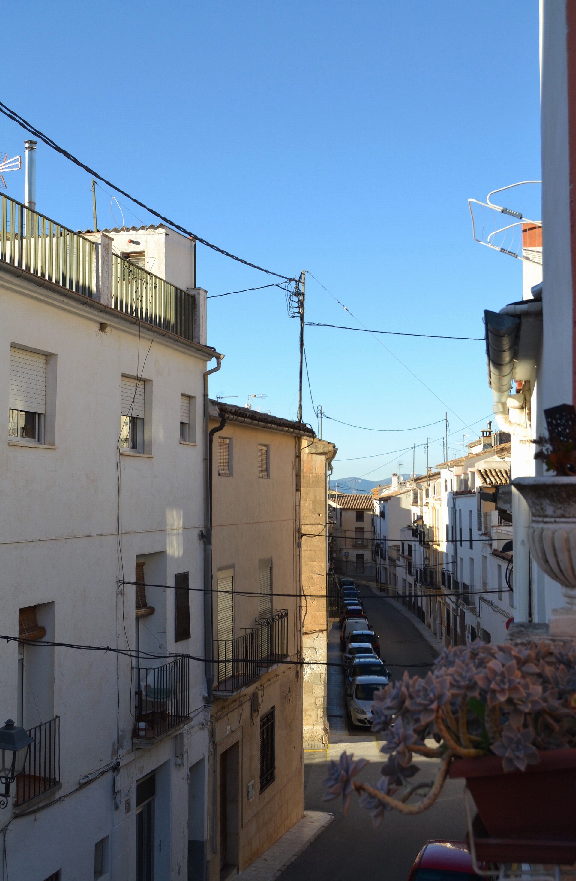 Alt text: "Cozy apartment with balcony, street view, and mountain backdrop.