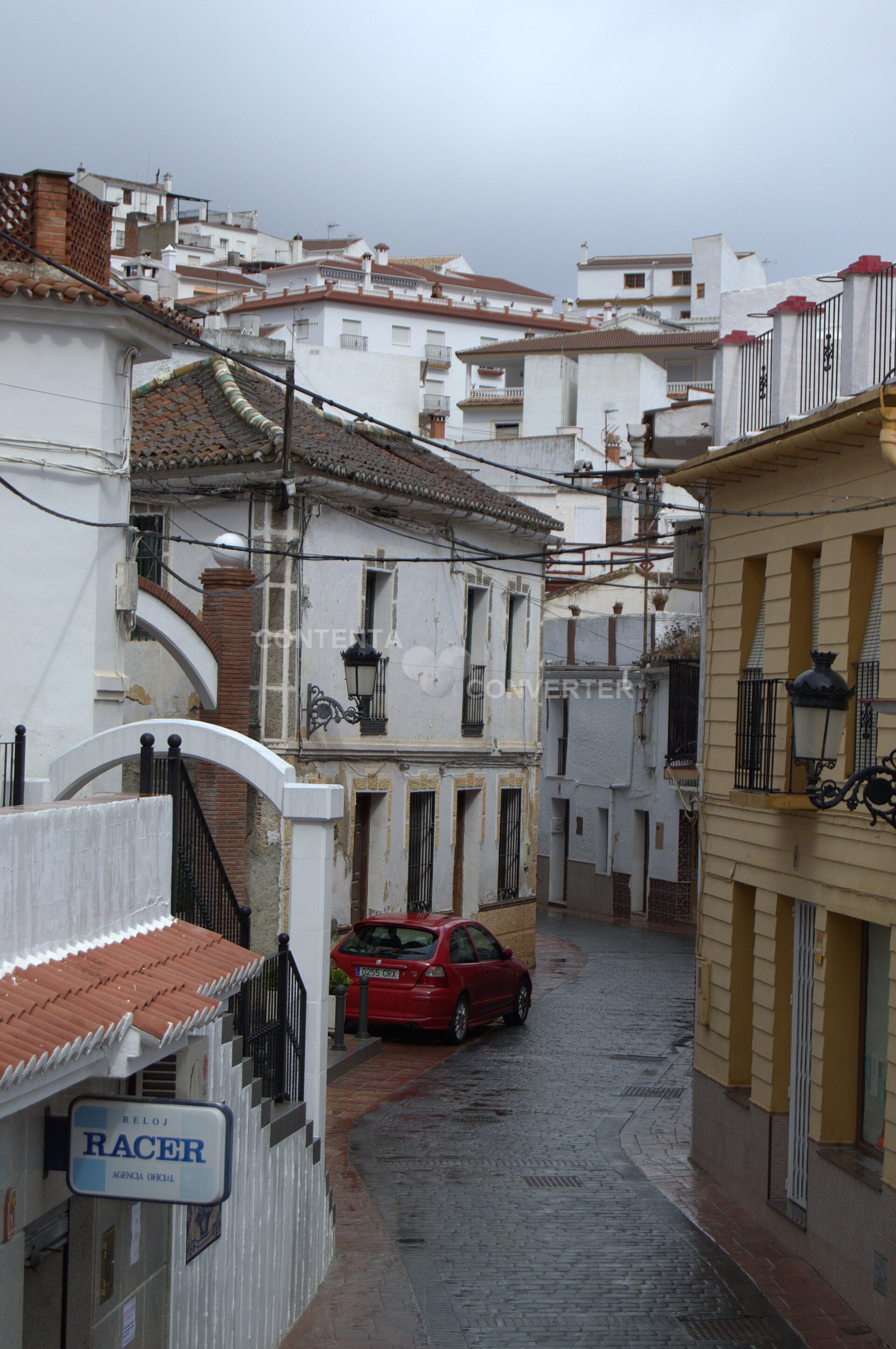 Traditional white-walled room with tiled roof, street view, balcony, and street lamp.