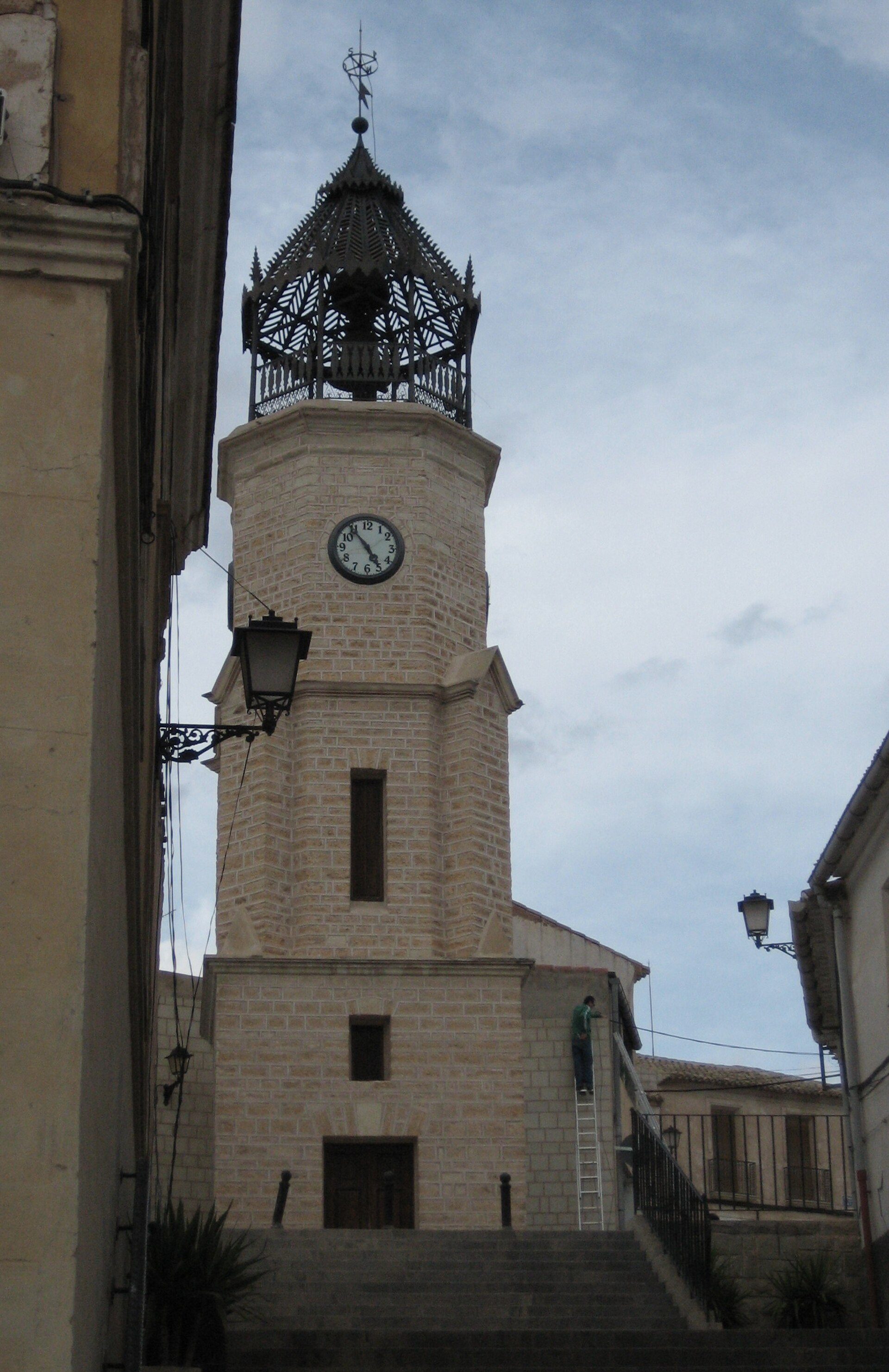 Alt text: Historic clock tower with a view of the sky, featuring a bell and ornate metalwork.