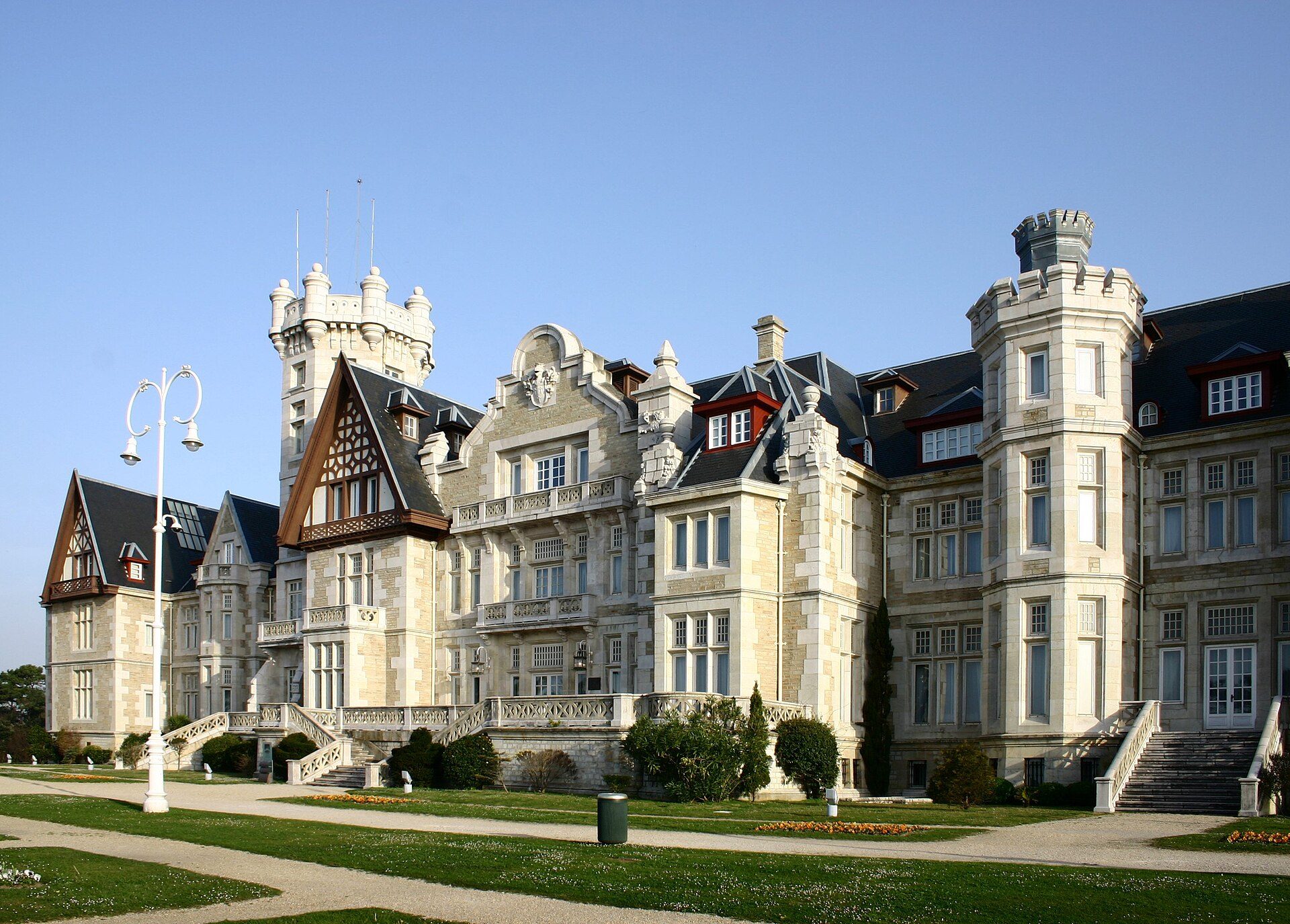 A grand castle with multiple towers, large windows, and a well-manicured garden.