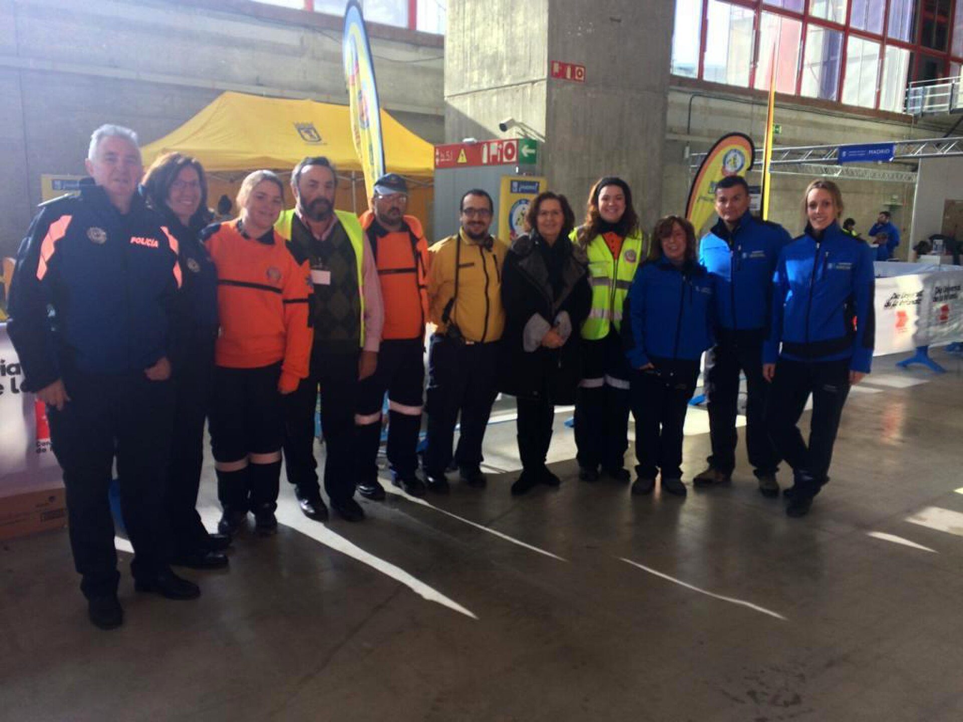 A group of people in safety gear posing indoors with banners and signs.