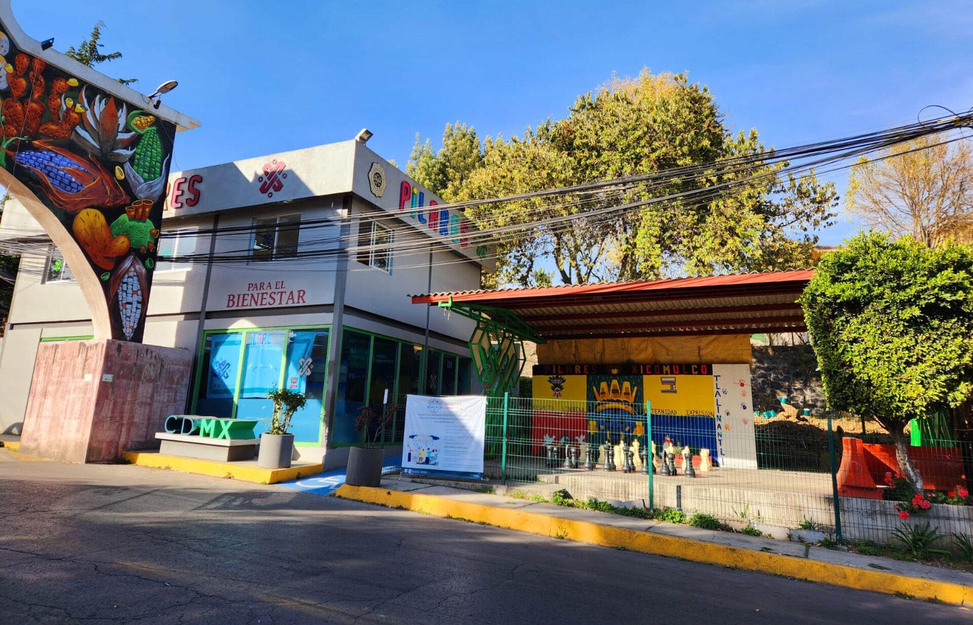 A colorful building with a mural, featuring a small shop and outdoor seating area.