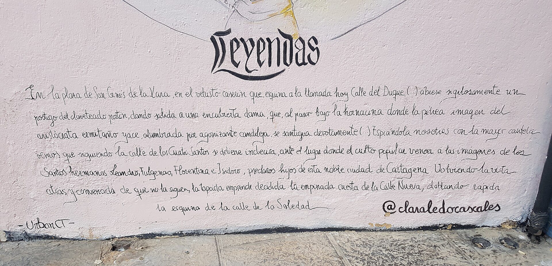Alt text: Mural with cursive text and decorative elements on a white wall.