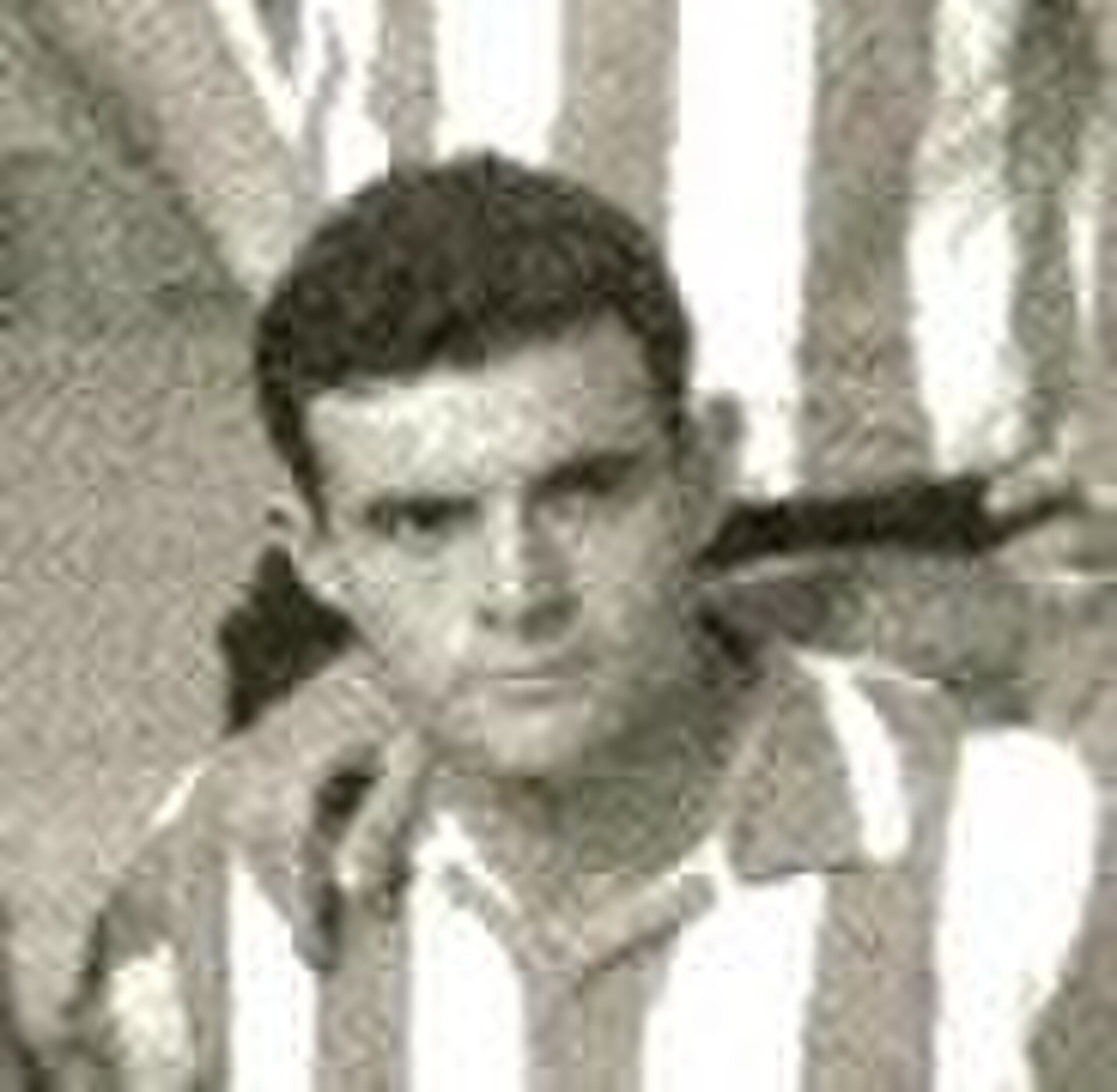 Alt text: Black and white photo of a man in a striped shirt.