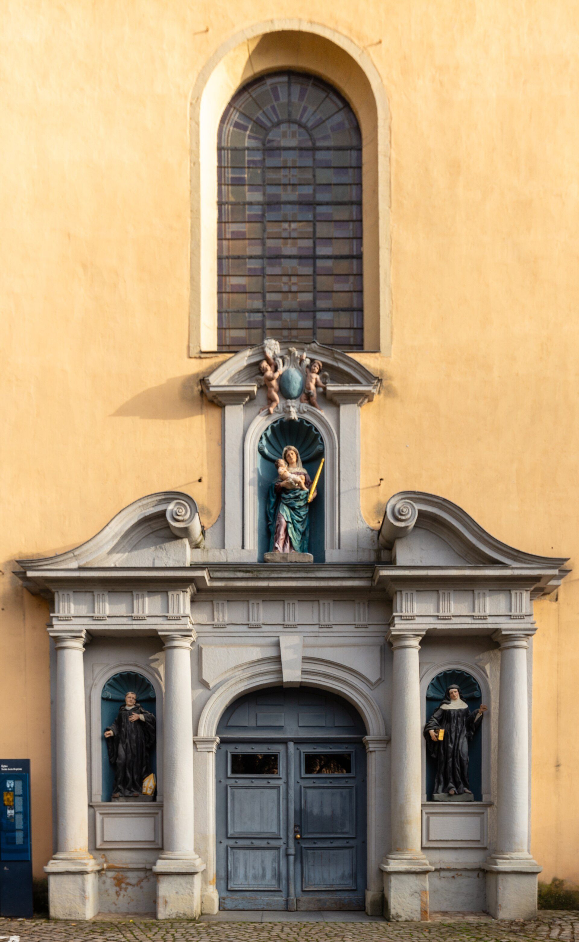 Alt text: Historic building with arched windows, statues, and a central door.