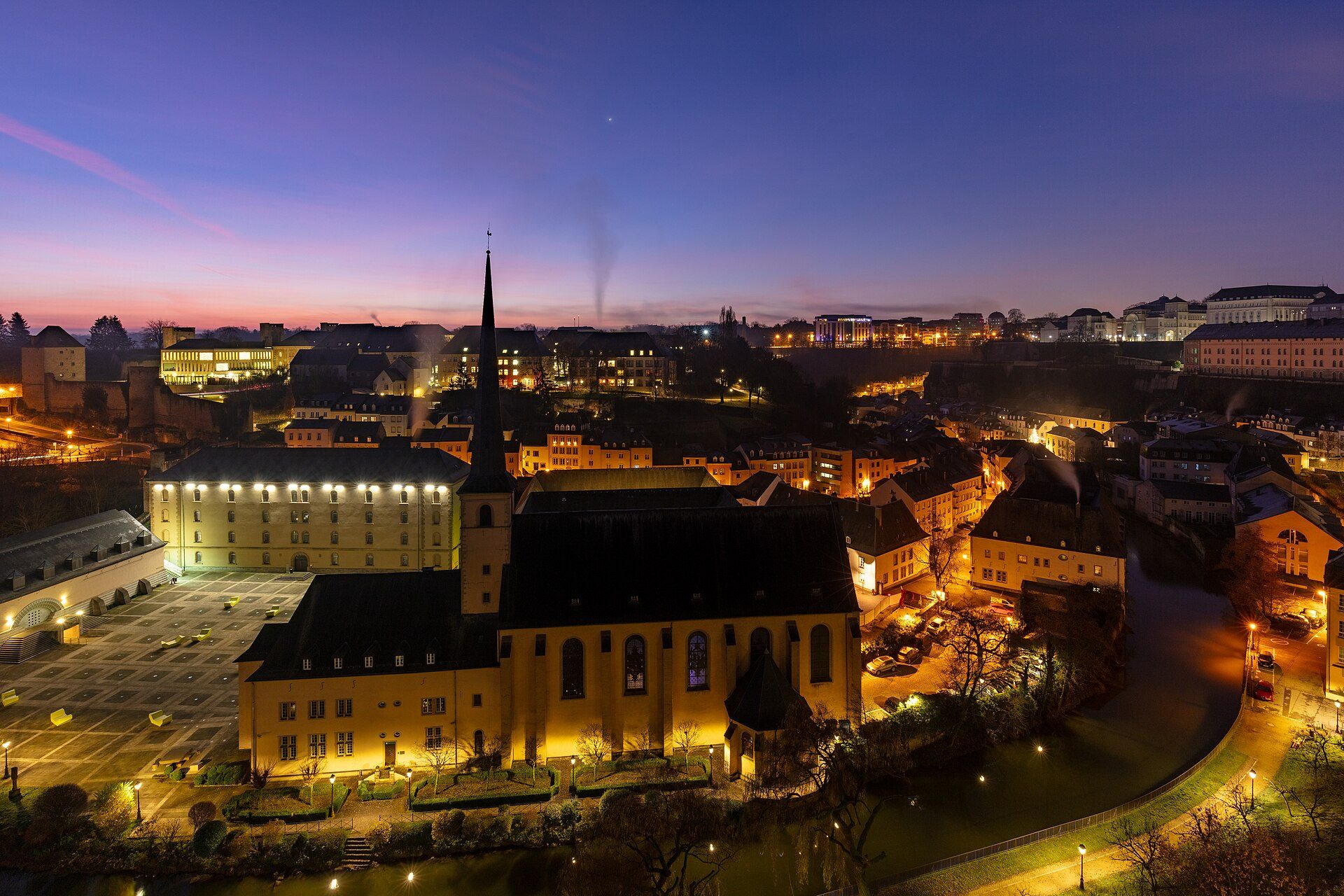 Alt text: Evening cityscape view from hotel room with church and river.