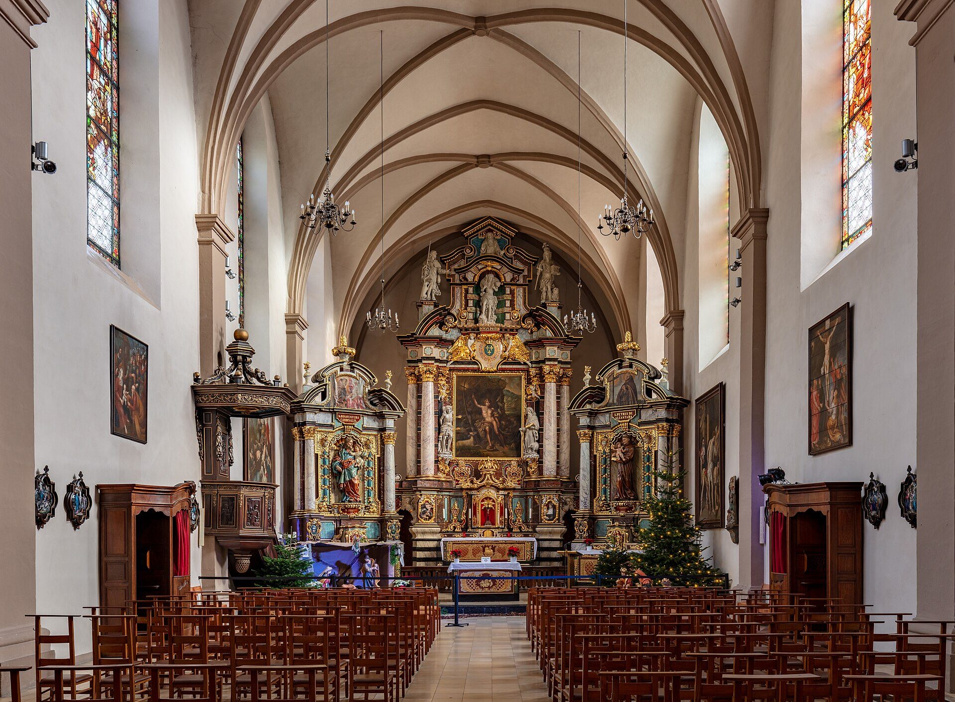 Alt text: Interior view of a church with wooden pews, stained glass windows, and ornate altar.