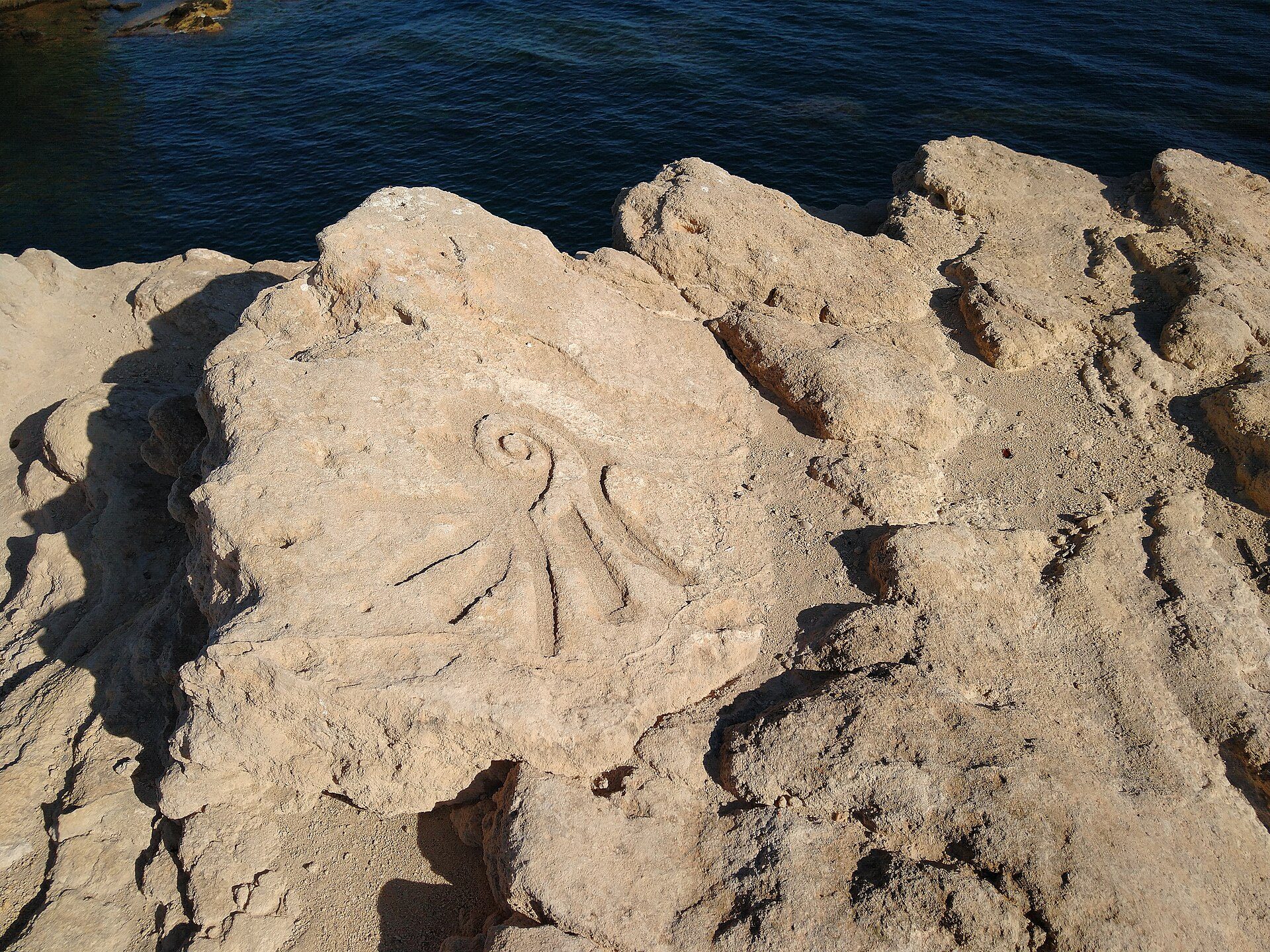 Figura grabada en roca en el acantilado frente a la Isla Negra en San Juan de lo