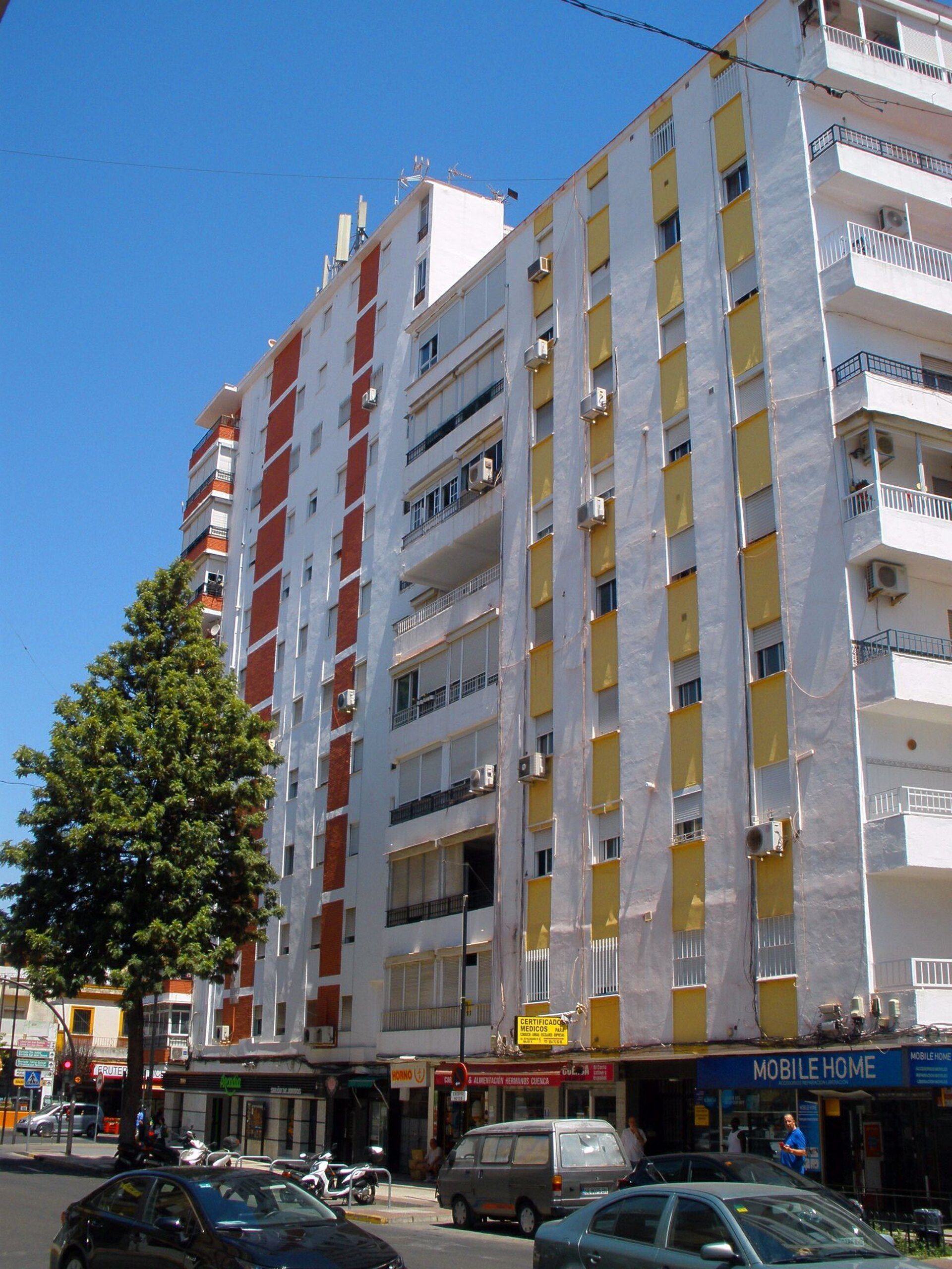 A modern apartment with a city view, featuring a balcony and large windows.