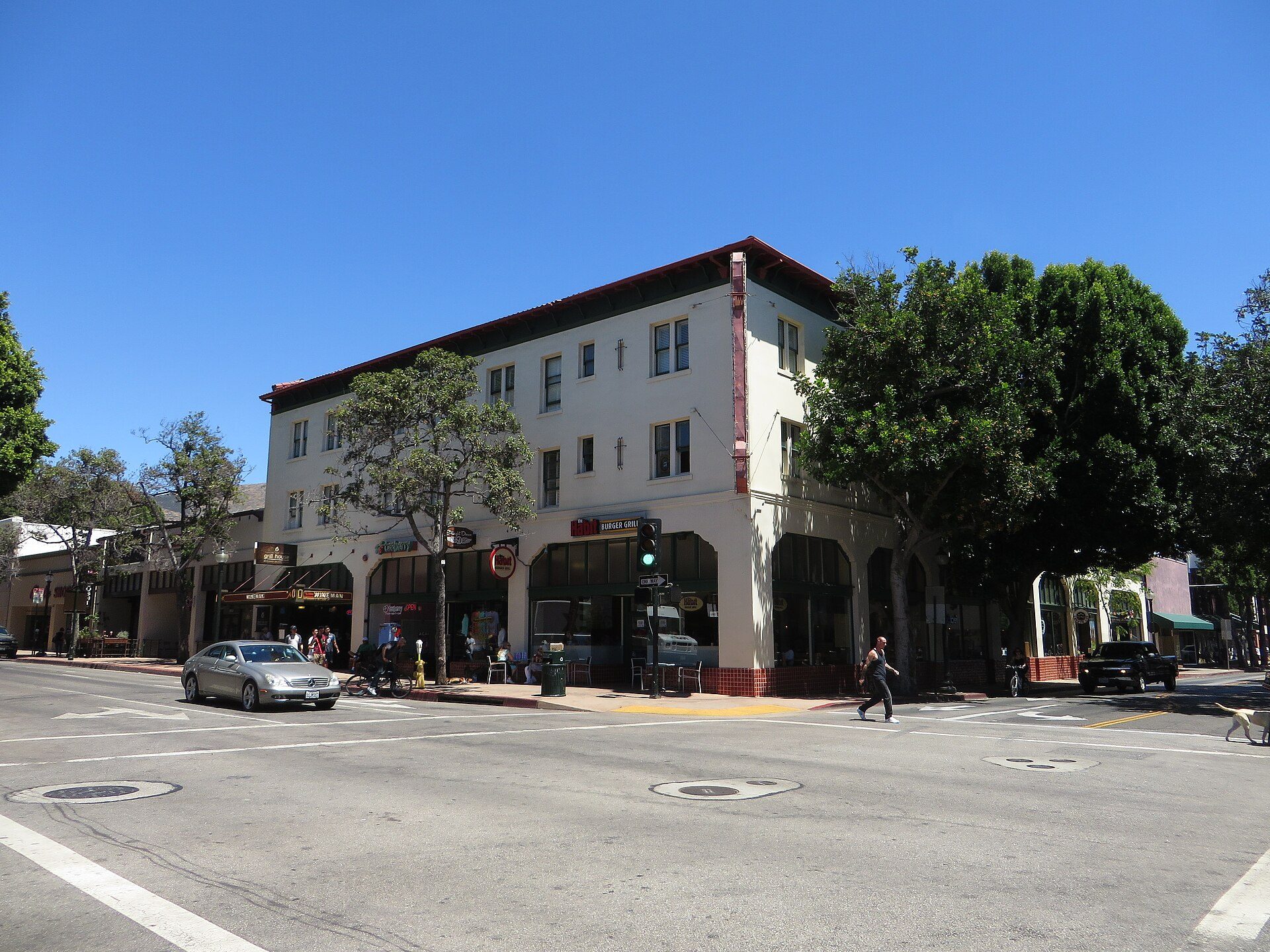 A two-story building with a street view, featuring large windows and a red roof.