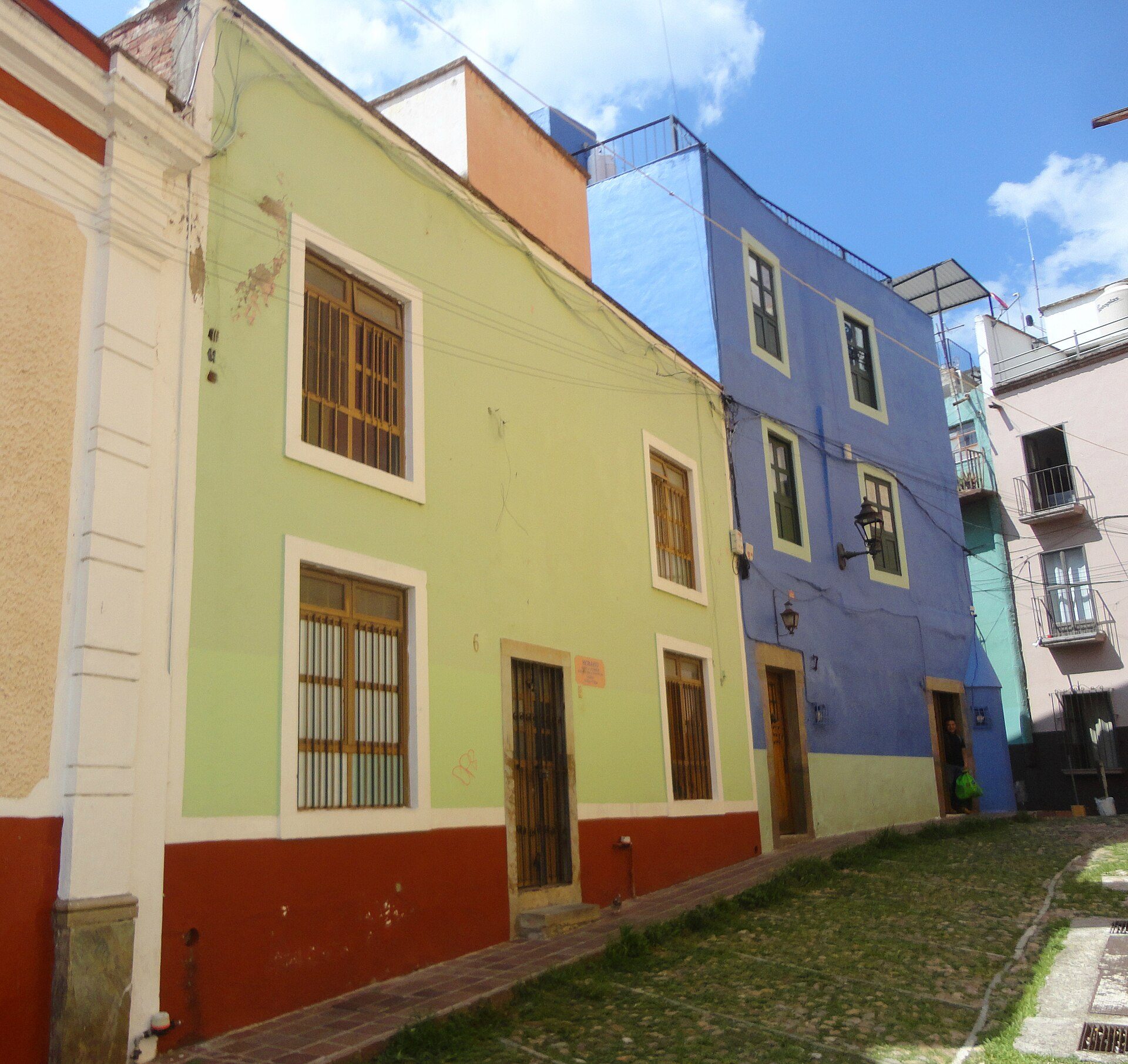 Two-story building with two bedrooms, balcony, and street view.