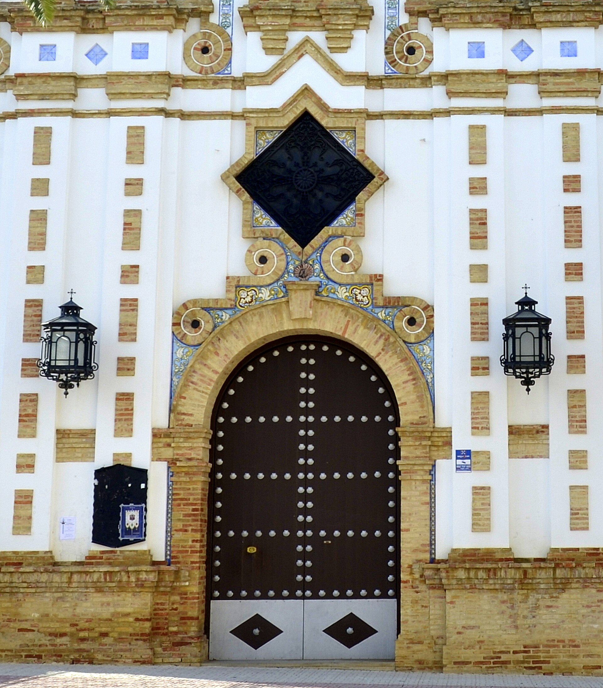 Alt text: Historic building with ornate entrance, featuring arched door and decorative tiles.