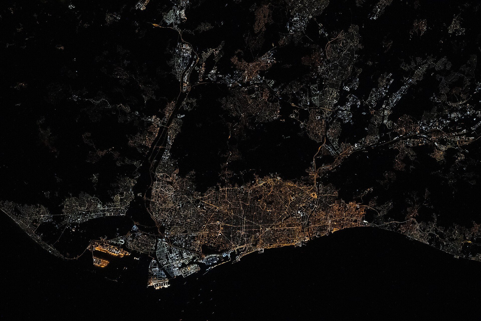 Aerial view of a city at night with illuminated streets and buildings.