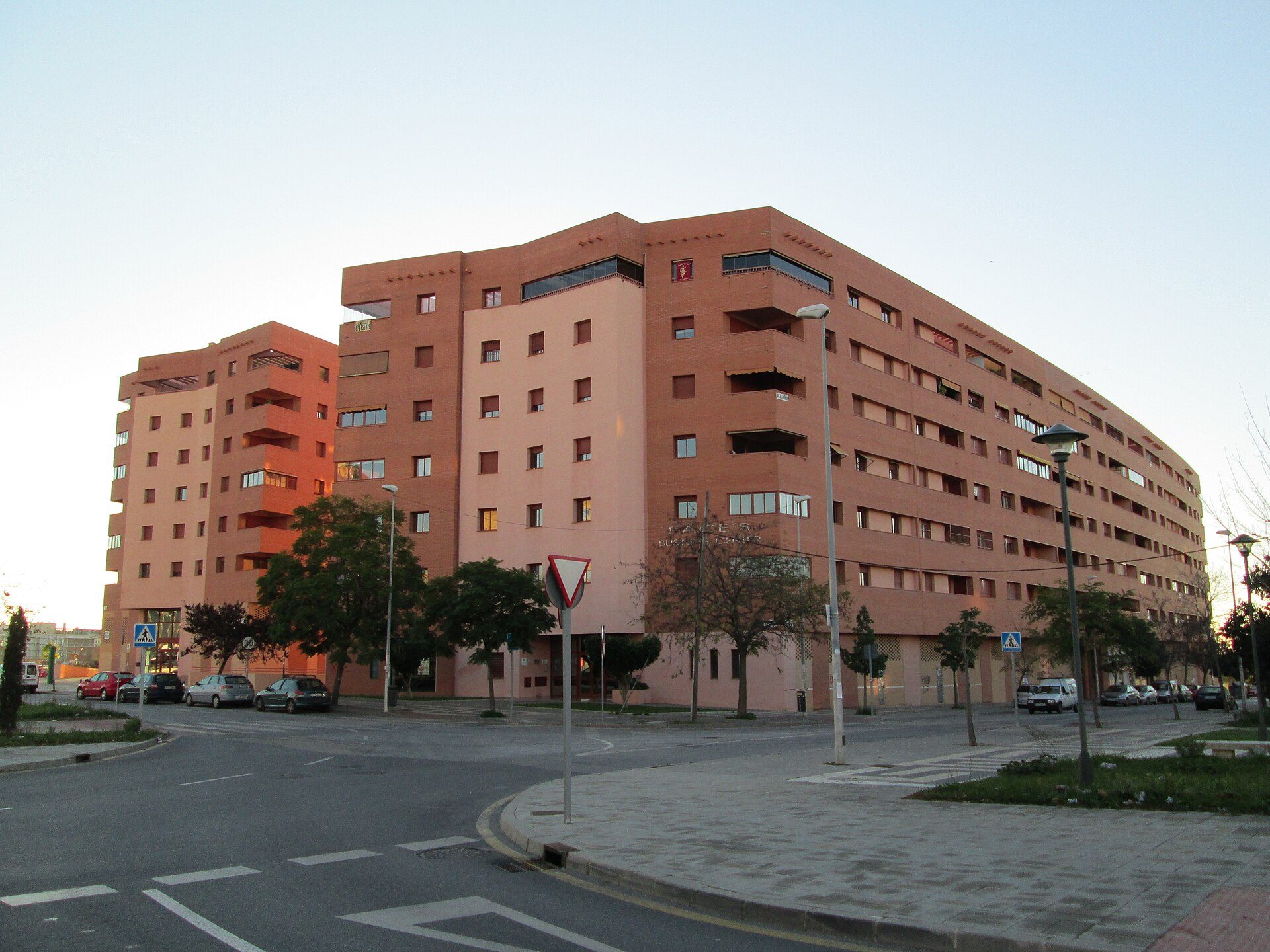 A modern apartment building with multiple balconies and a city view.