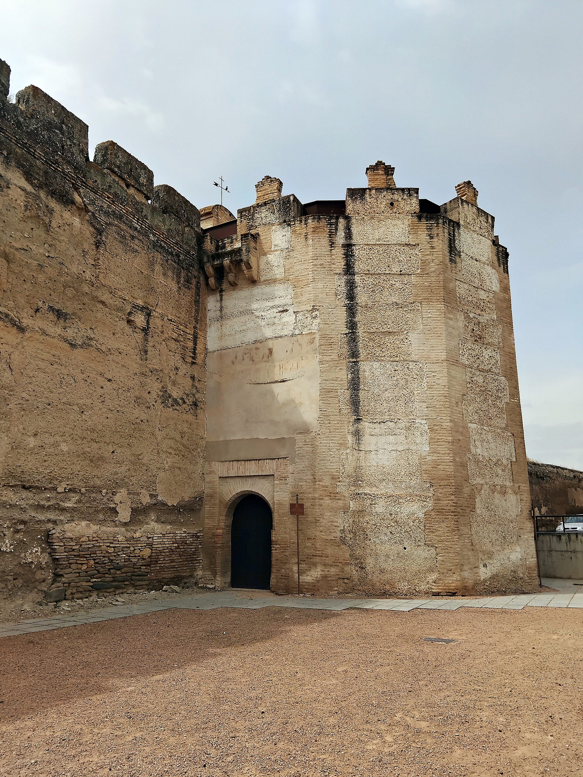 Old stone fortress with arched entrance, historical architecture, scenic view.