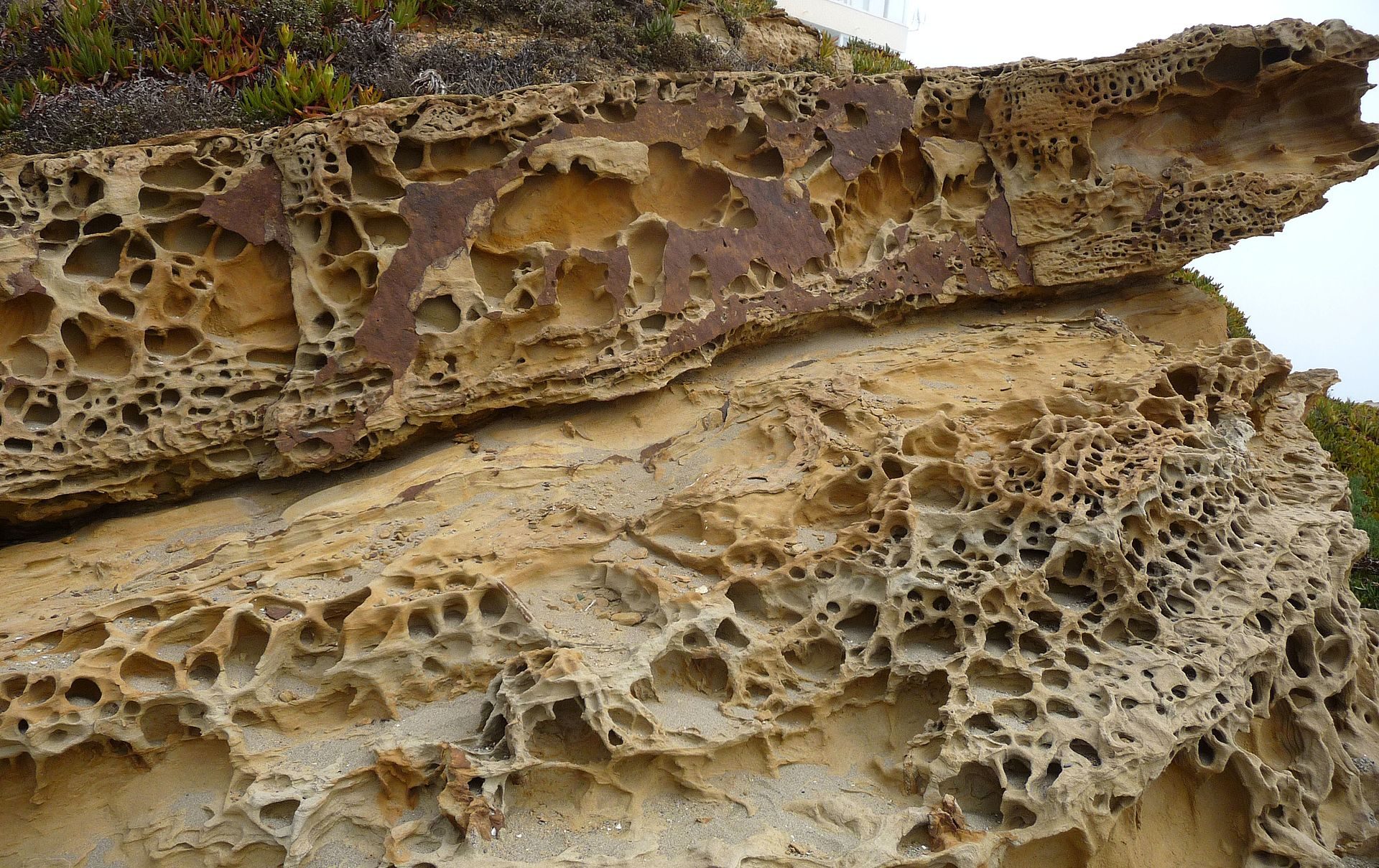 Alt text: Interior view of a cozy, rustic room with a large, textured stone fireplace.