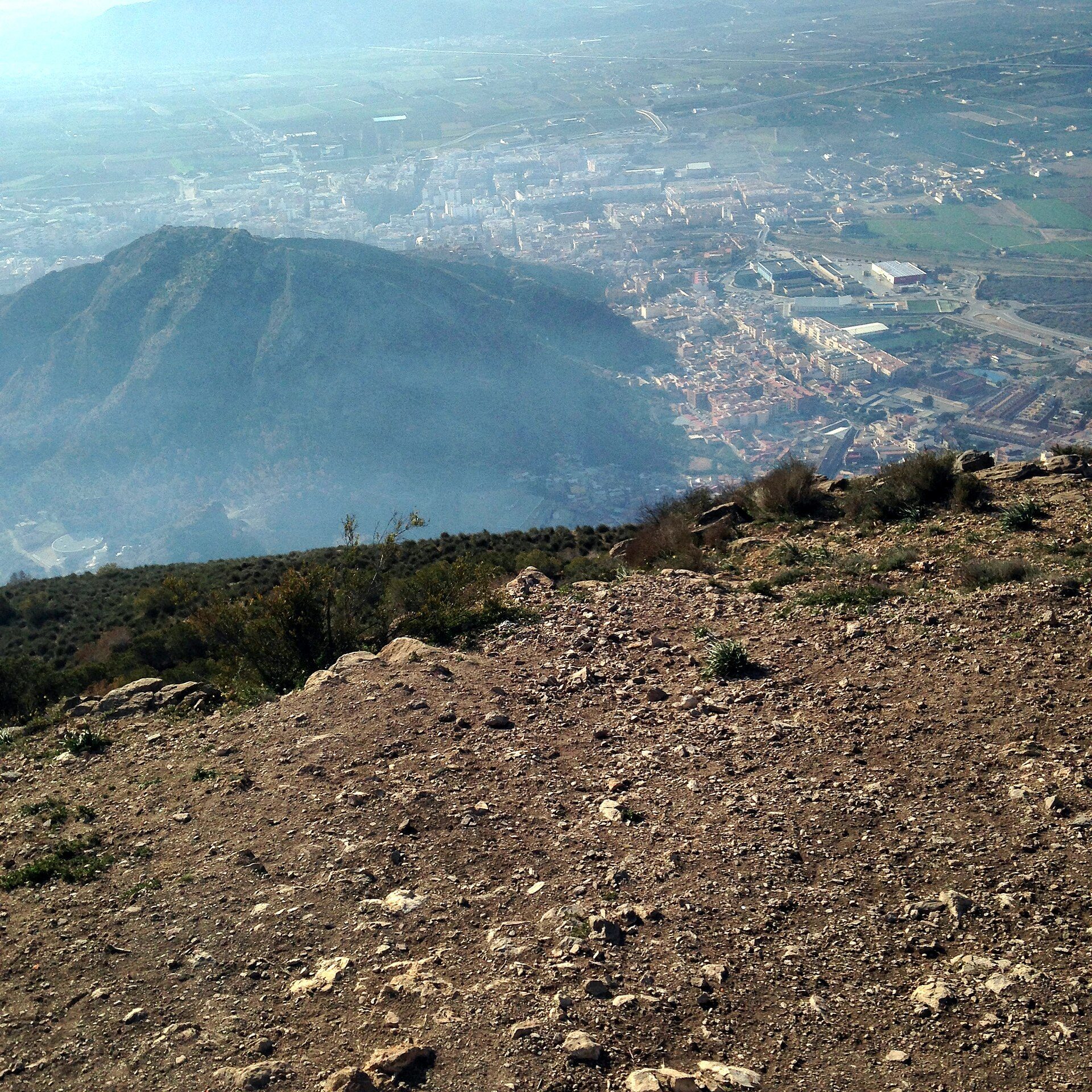 Alt text: Panoramic view of a cityscape from a mountainous room with rocky terrain.
