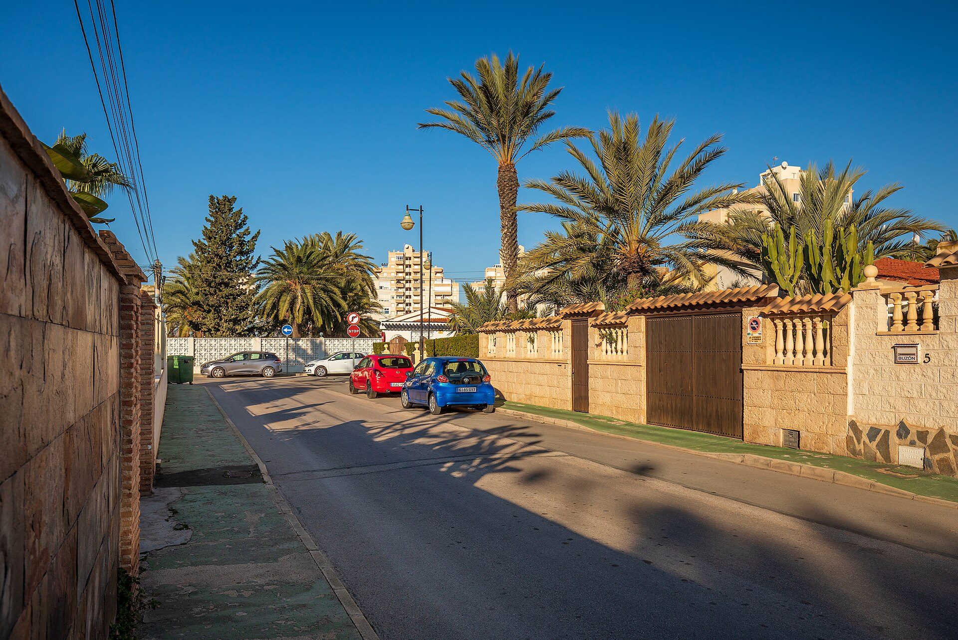 A cozy apartment with a balcony, offering a view of palm trees and a clear blue sky.