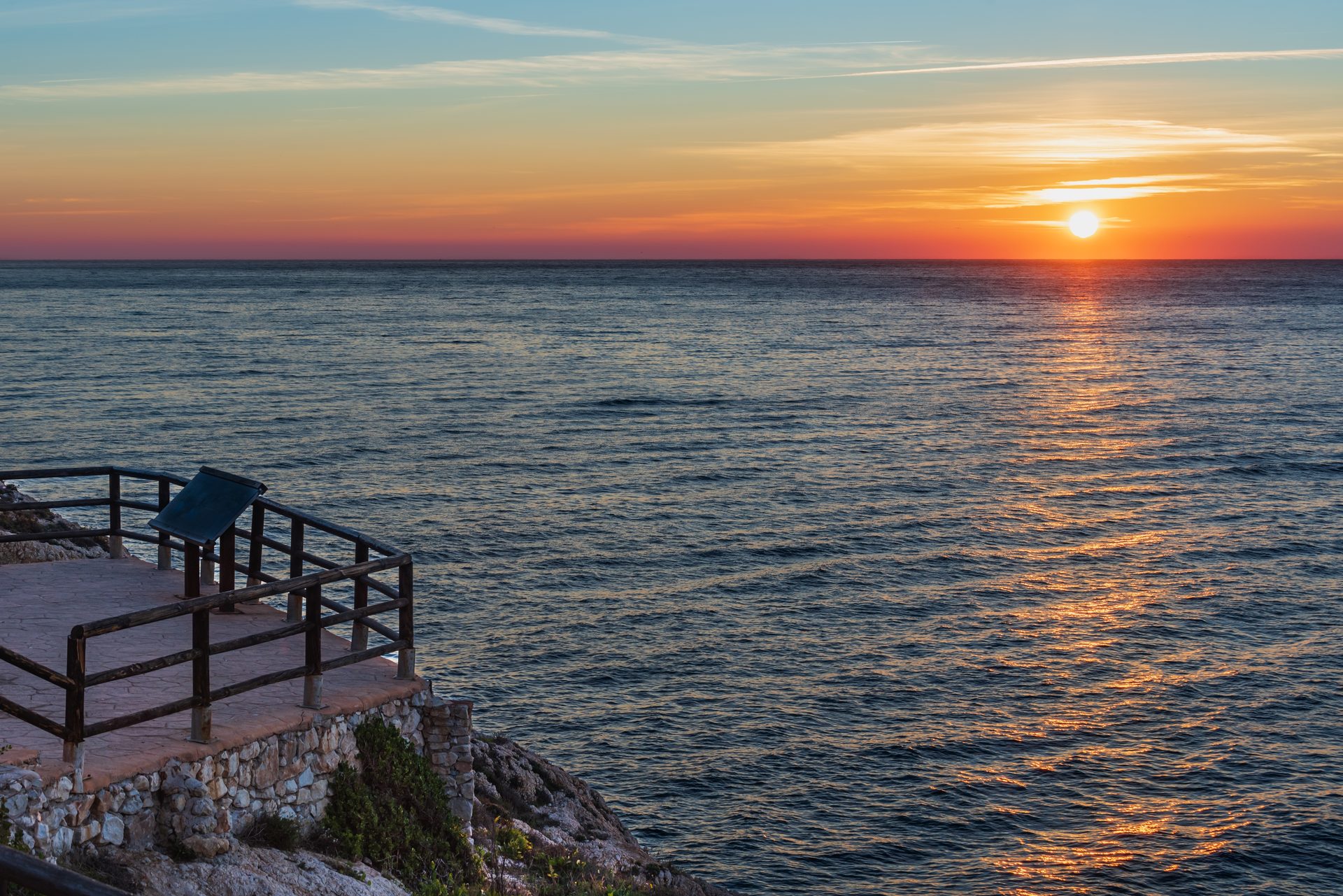 Sunset view from a balcony overlooking the ocean.