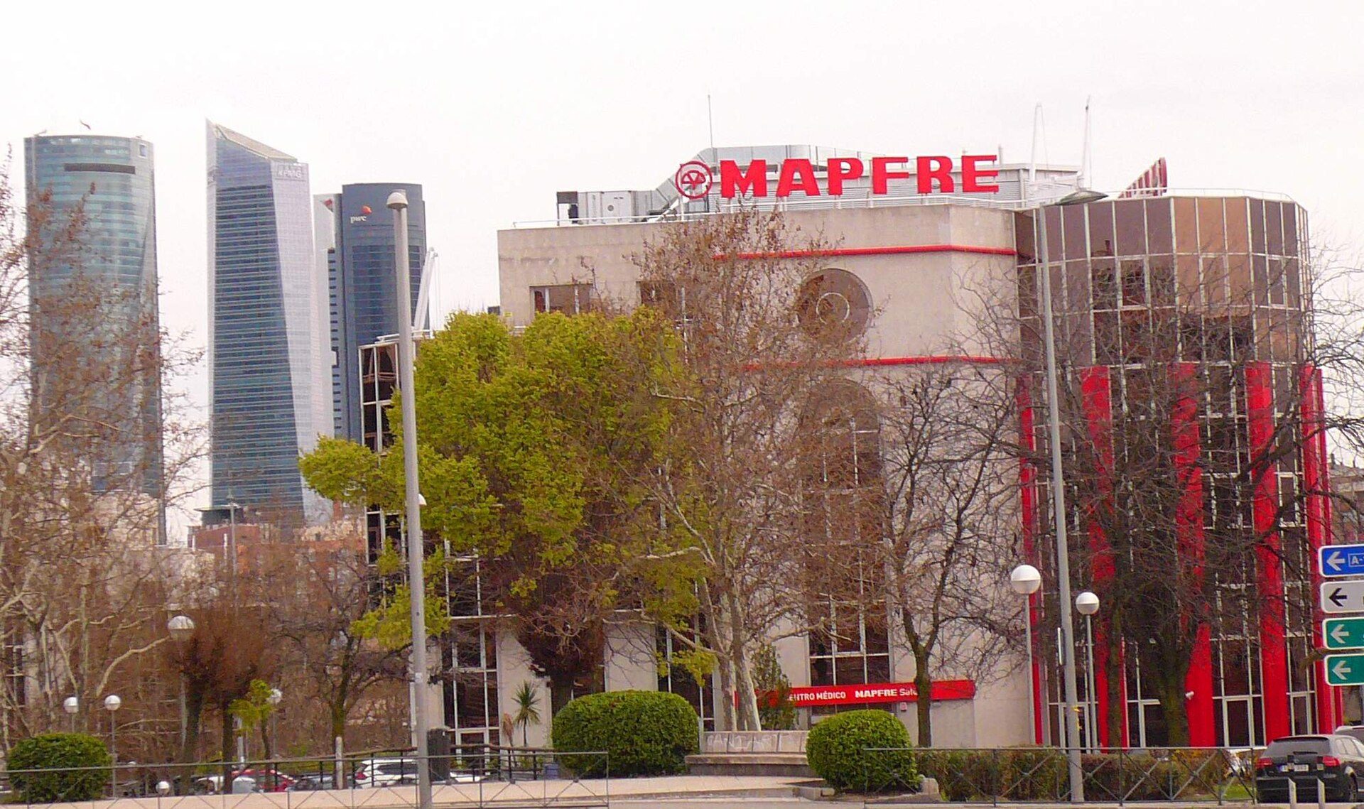Modern hotel room with city view, balcony, and large windows.