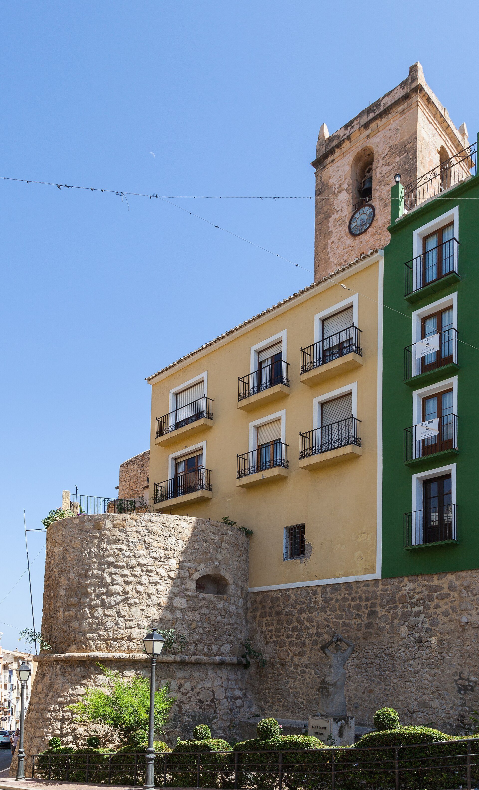 Traditional apartment with balcony, stone walls, and clock tower view.