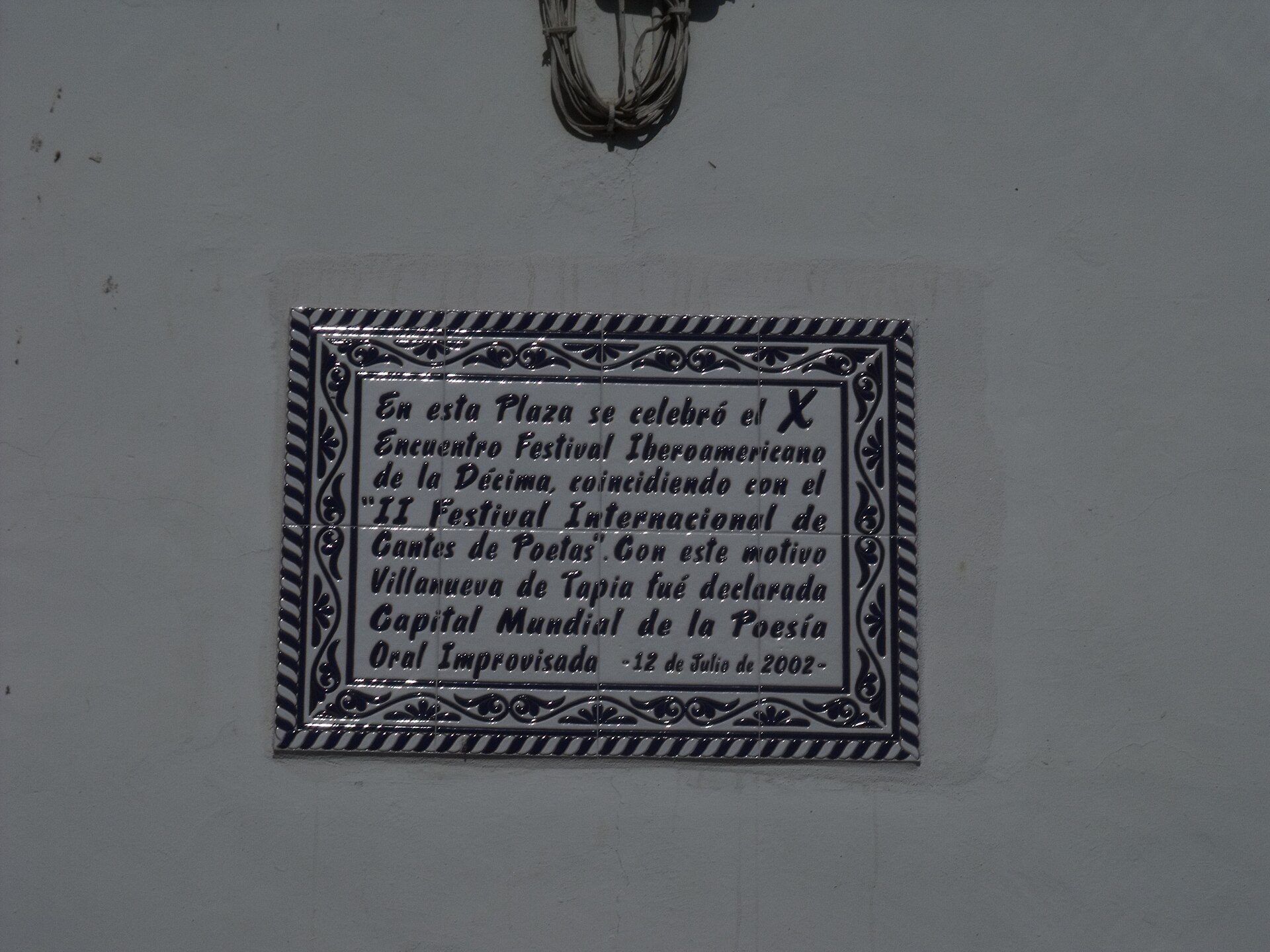 Placa cerámica en la plaza de la iglesia