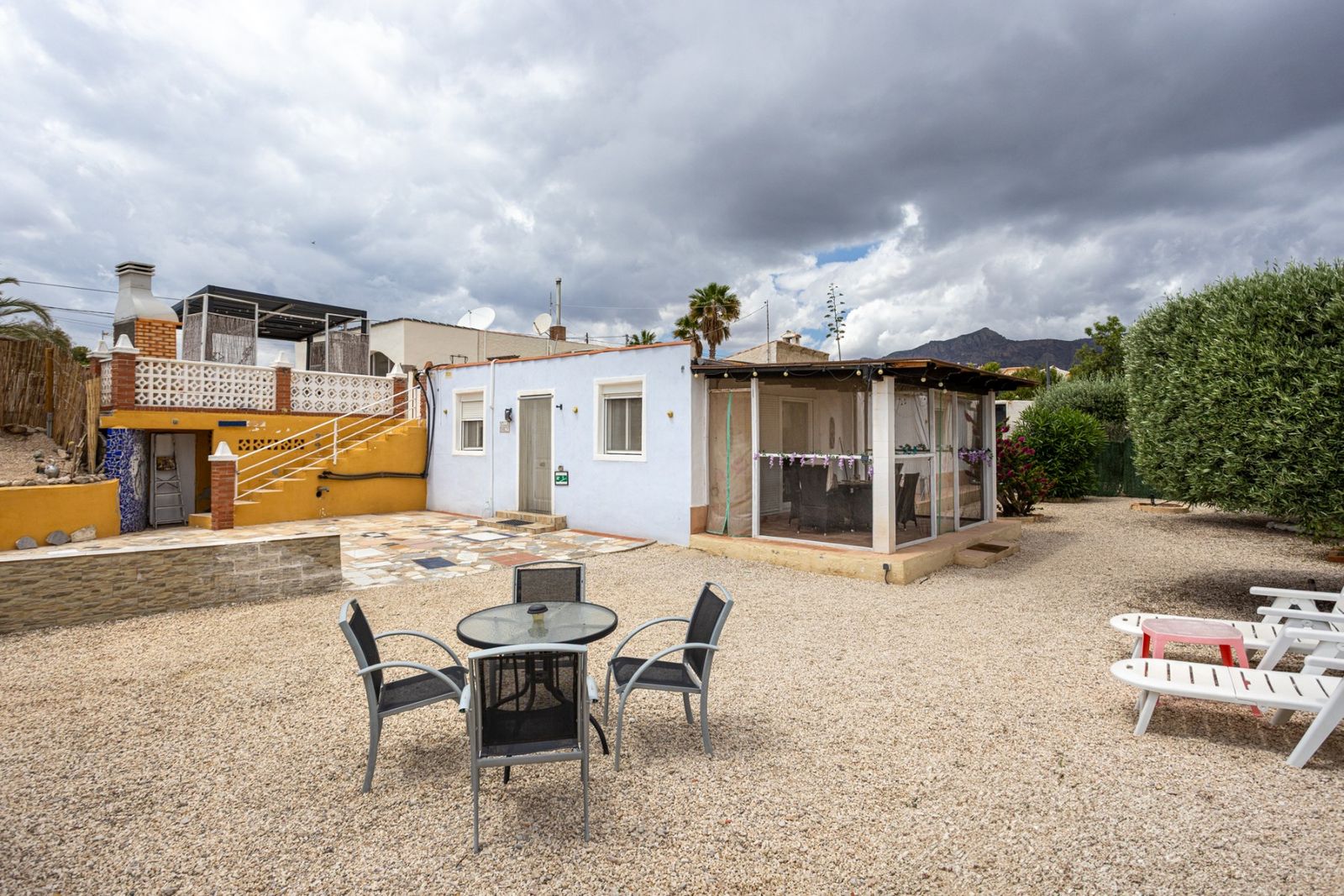 Buitenaanzicht van een woning met patio en tuinmeubilair.
