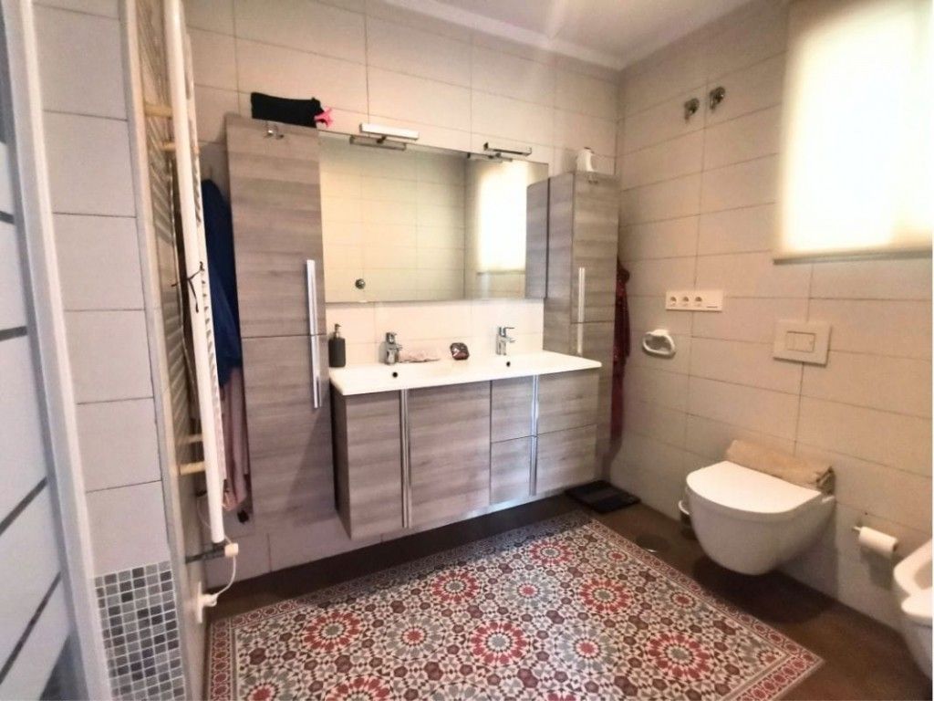 Stijlvolle badkamer interieur met dubbele wastafel en decoratief vloerkleed.