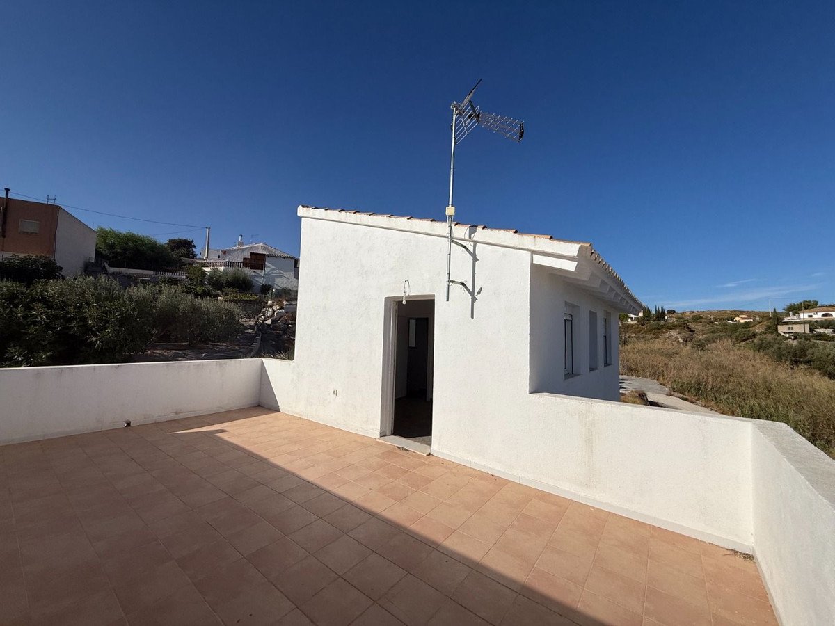 White villa with tiled terrace and clear blue sky view