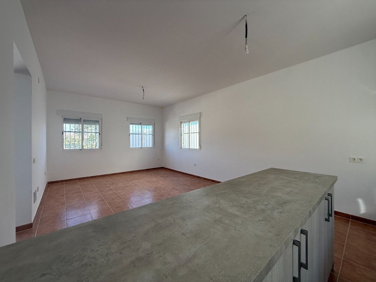 Empty living room with tiled floor, white walls, and three windows