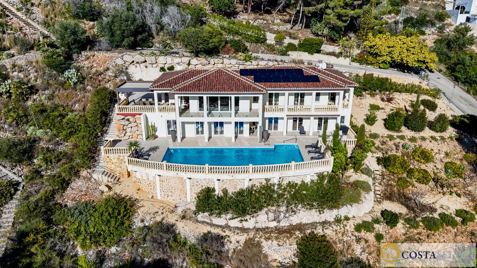 Luxe villa met zwembad en zonnepanelen, gezien vanuit de lucht