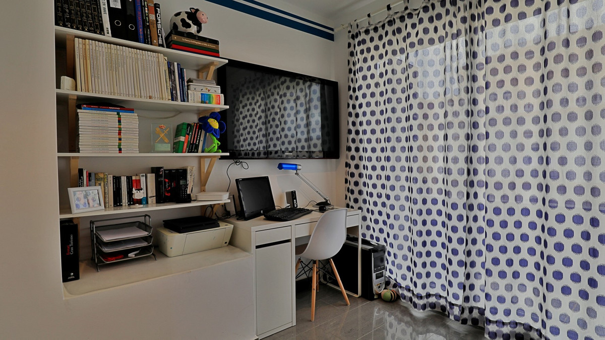Georganiseerde thuiswerkplek met bureau, boekenplank en gordijnen met stippen