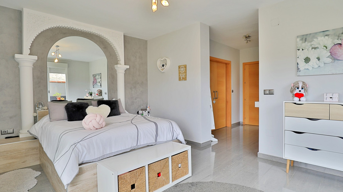 Stijlvolle slaapkamer interieur met bed, spiegel en decoratie.