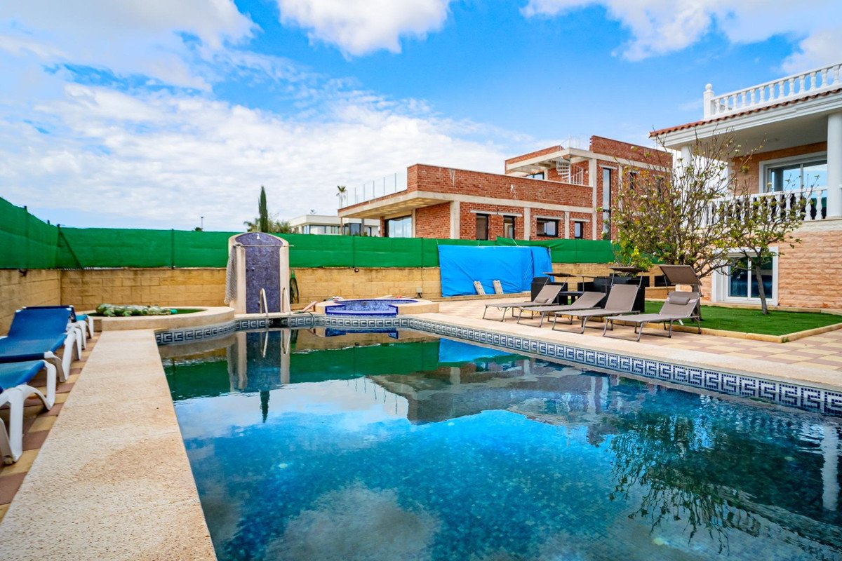 Swimming pool with lounge chairs and view of modern houses