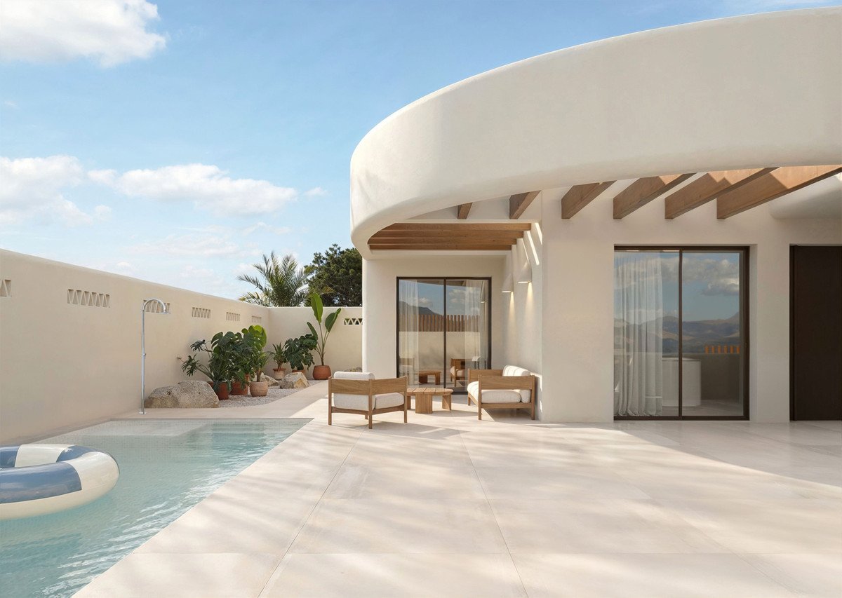 Modern white villa with a private pool, outdoor seating area, and a scenic mountain view.