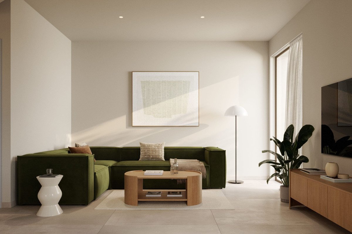 Modern living room with a deep green sectional sofa, minimalist coffee table, abstract art, and a large window with sheer curtains.