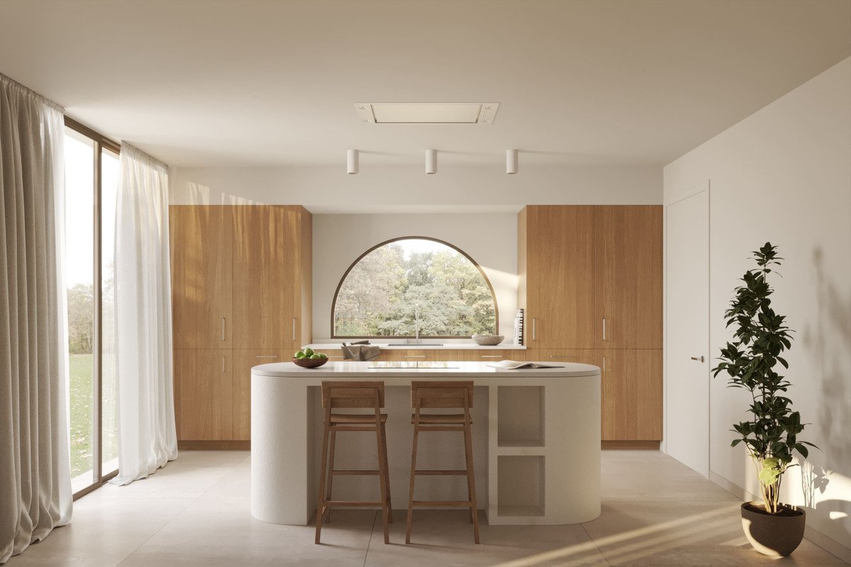 A modern kitchen with a curved island, wooden cabinets, and a large arched window overlooking trees.
