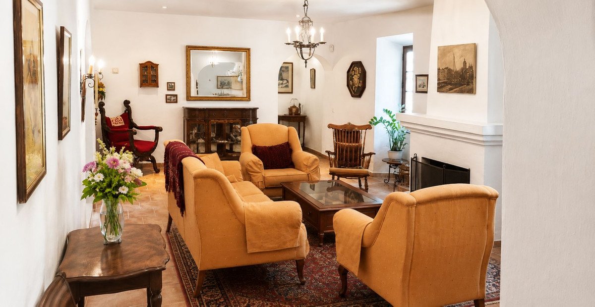 Cozy living room with orange armchairs, fireplace, and vintage decor.