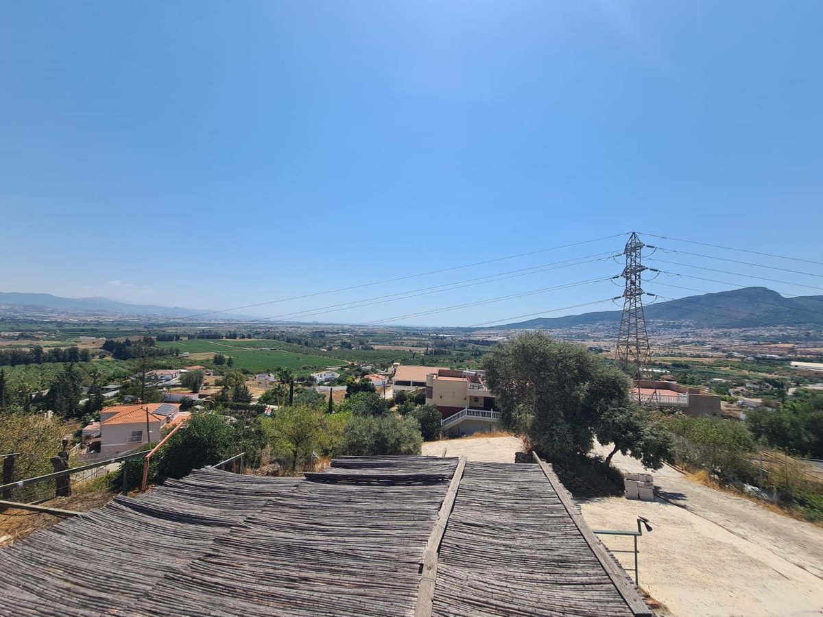 Village view from rooftop with clear blue sky and distant mountains