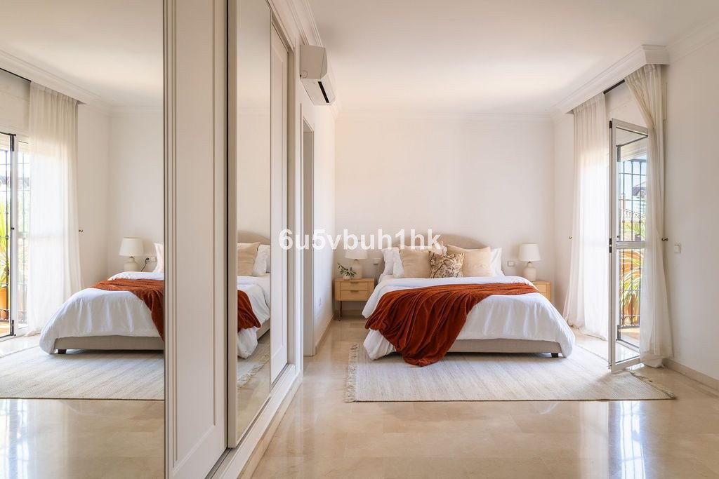 Spacious master bedroom with a queen-sized bed, mirrored closet, and a balcony door leading to an outdoor terrace.