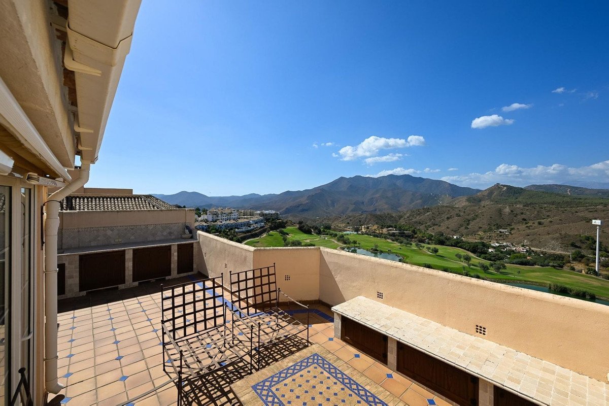 Terrace with seating and mountain and golf course views under a clear blue sky.