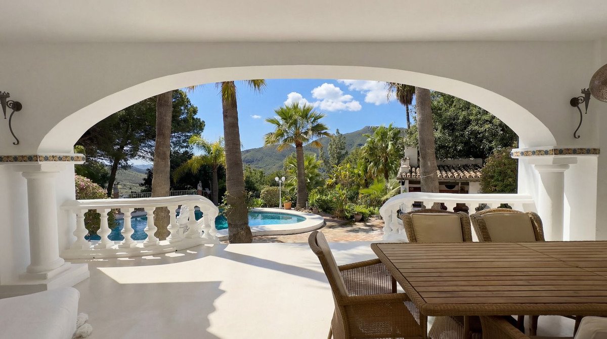 White patio with swimming pool and tropical view