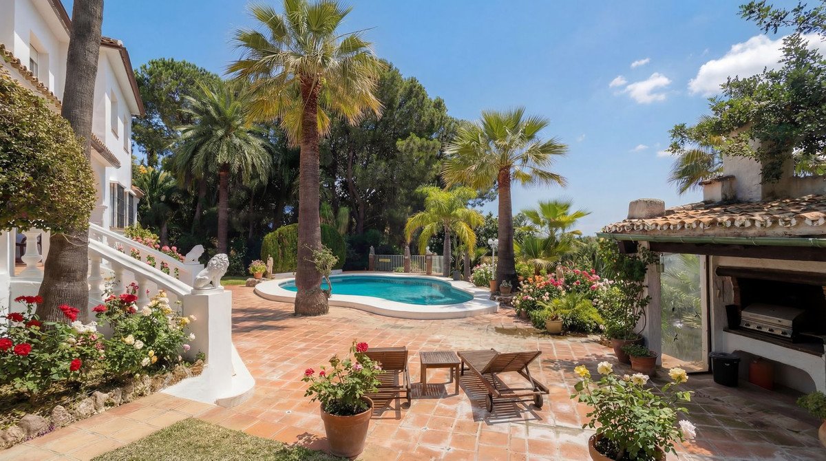 Luxurious outdoor lounge with swimming pool, palm trees, and garden seating